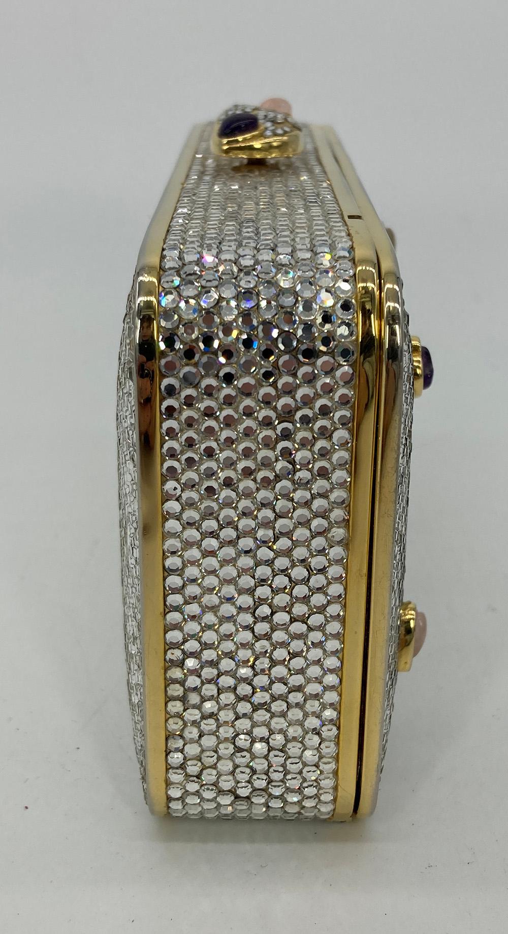 Judith Leiber Crystal Gemstone Hearts Minaudiere in excellent condition. Clear crystal exterior trimmed with gold hardware and multi colored gemstone hearts along front side. Top button closure with pink and purple heart stones. Gold leather