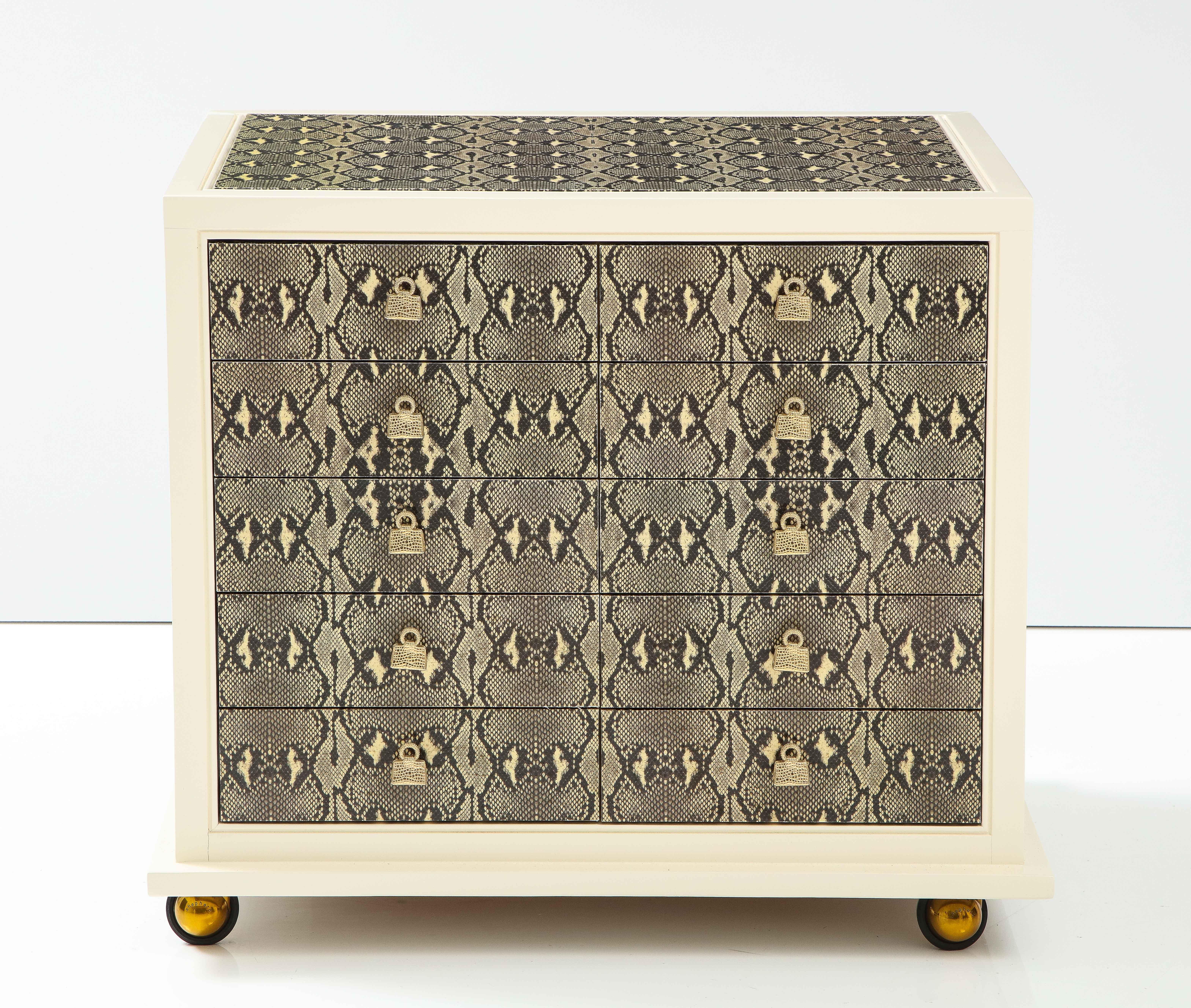 Judith Leiber Custom designed cabinet for the Madison Avenue store.
The custom  10 drawer cabinet with a Faux snakeskin print is a backdrop for the exquisite 
designed Gold Handbag drawer pulls.
The drawers all have removable velvet lined bottoms