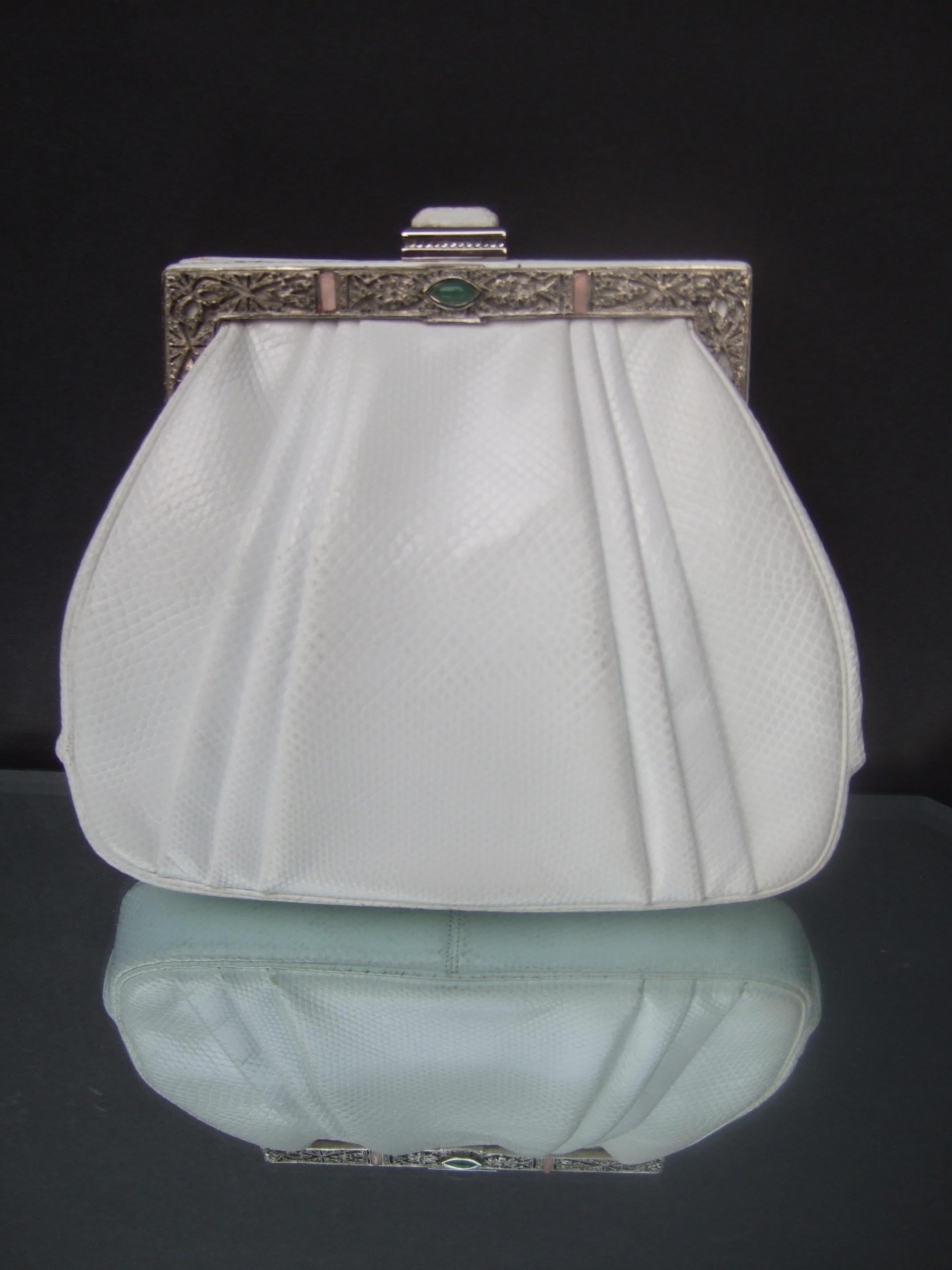 JUDITH LEIBER Elegant white karung leather versatile clutch - shoulder bag c 1980s 
The small clutch style handbag is designed with an ornate silver tone metal clasp frame 
with a pair of small muted pink glass baguettes & a small jade green color
