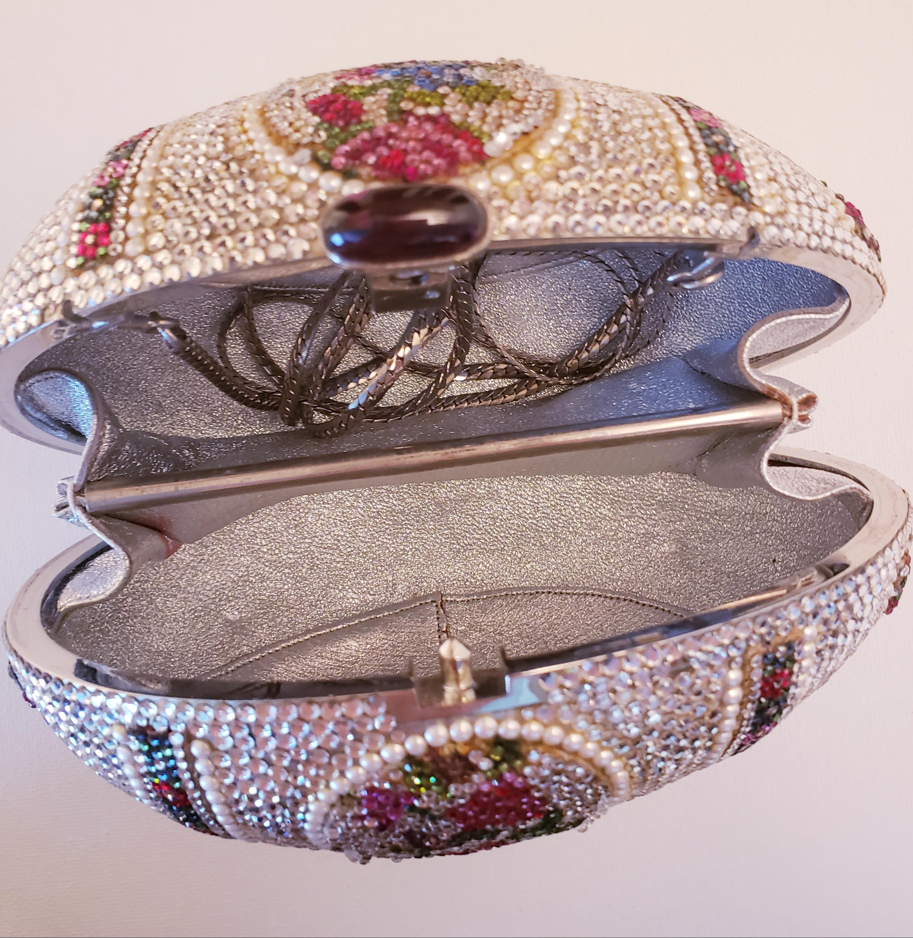 Judith Leiber egg minaudiere multicolor swarovski crystal design with delicate pearl details. Button closure opens to a silver leather interior with separate compartments and attached silver chain shoulder strap.  A true work of art. 
Measurements: