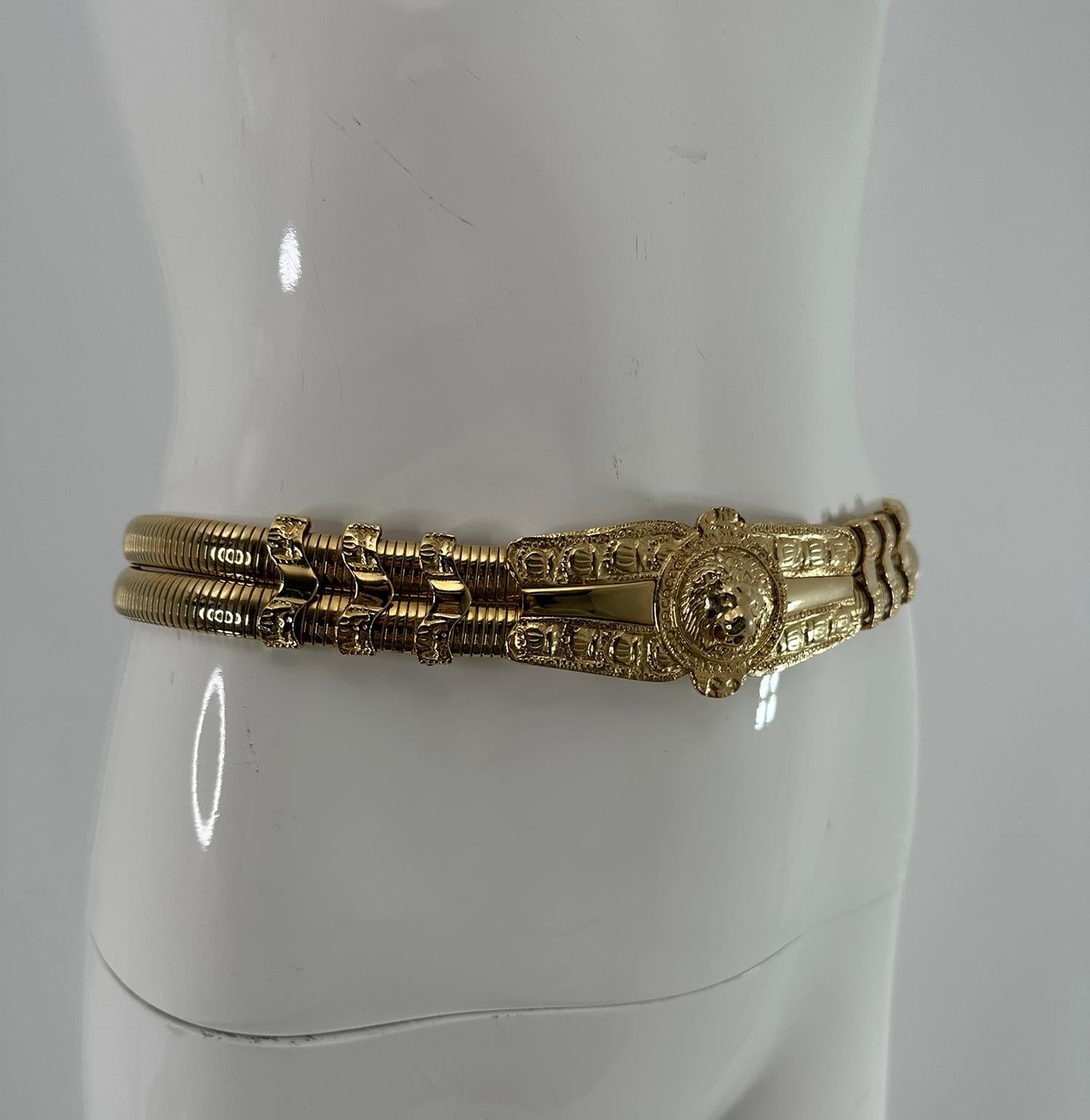 Judith Leiber in metallo dorato, fibbia a testa di leone, cintura a espansione. La splendida cintura sembra essere stata indossata a malapena, se non addirittura mai. Due file di fasce elastiche in metallo dorato. Si allunga da 28-30 pollici x 1 1/8