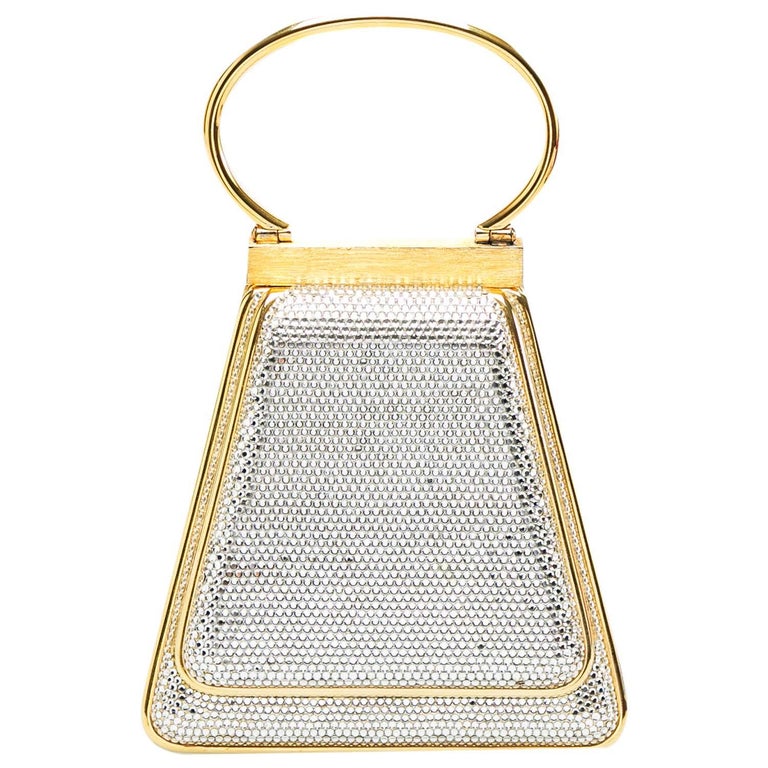 Creations so breathtaking and creative are hard to find! This awe-inspiring Minaudiere clutch from Judith Leiber is just what you need to grab all the attention at those soirees and parties. Covered from Swarovski crystals, it has a structured body