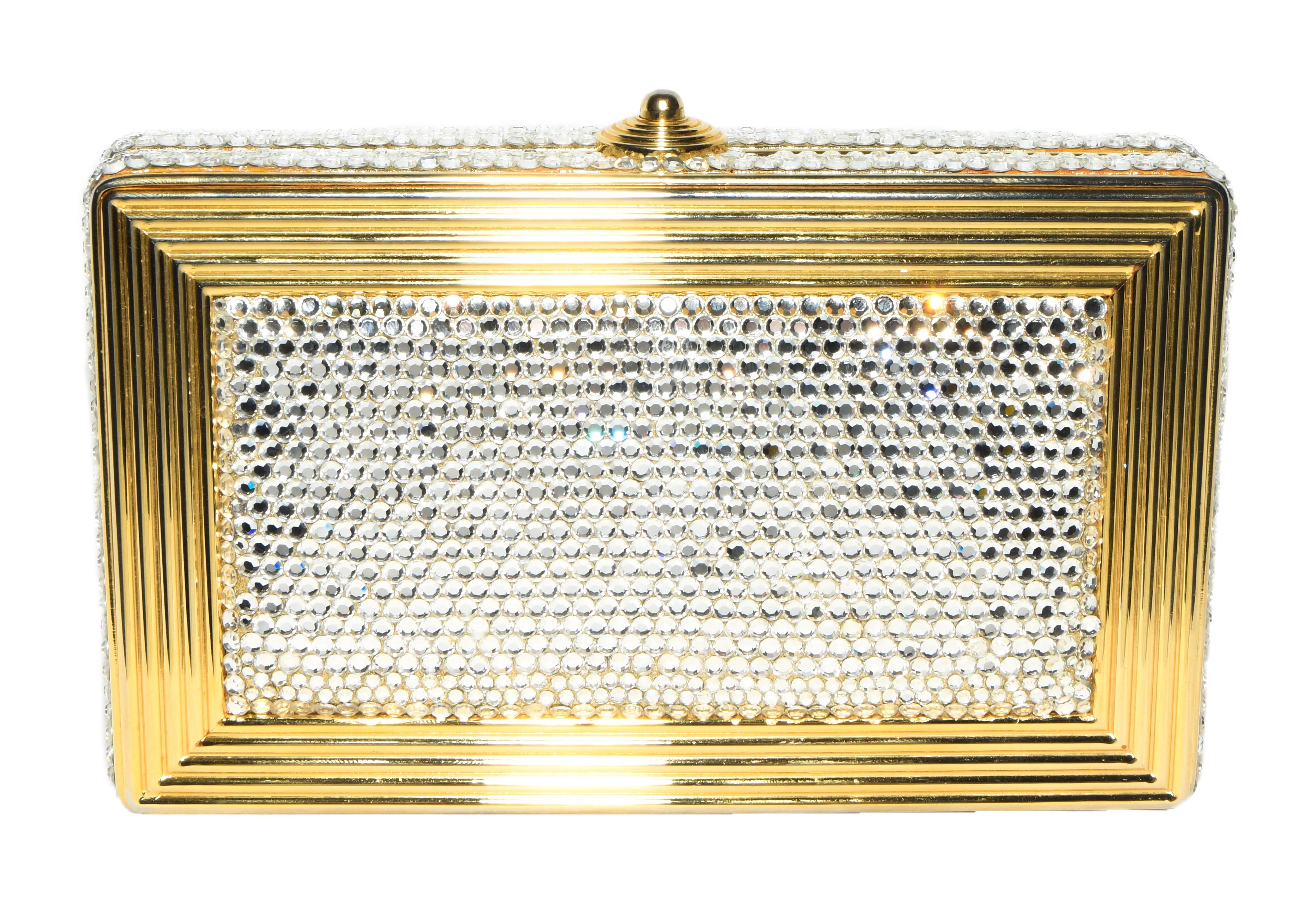 Judith Leiber crystal and gold tone metal minaudiere with top push button closure and includes a gold tone shoulder strap chain.  This Judith Leiber silver  Swarovski crystal clutch bag is lined in gold tone leather.  This elegant clutch is encased