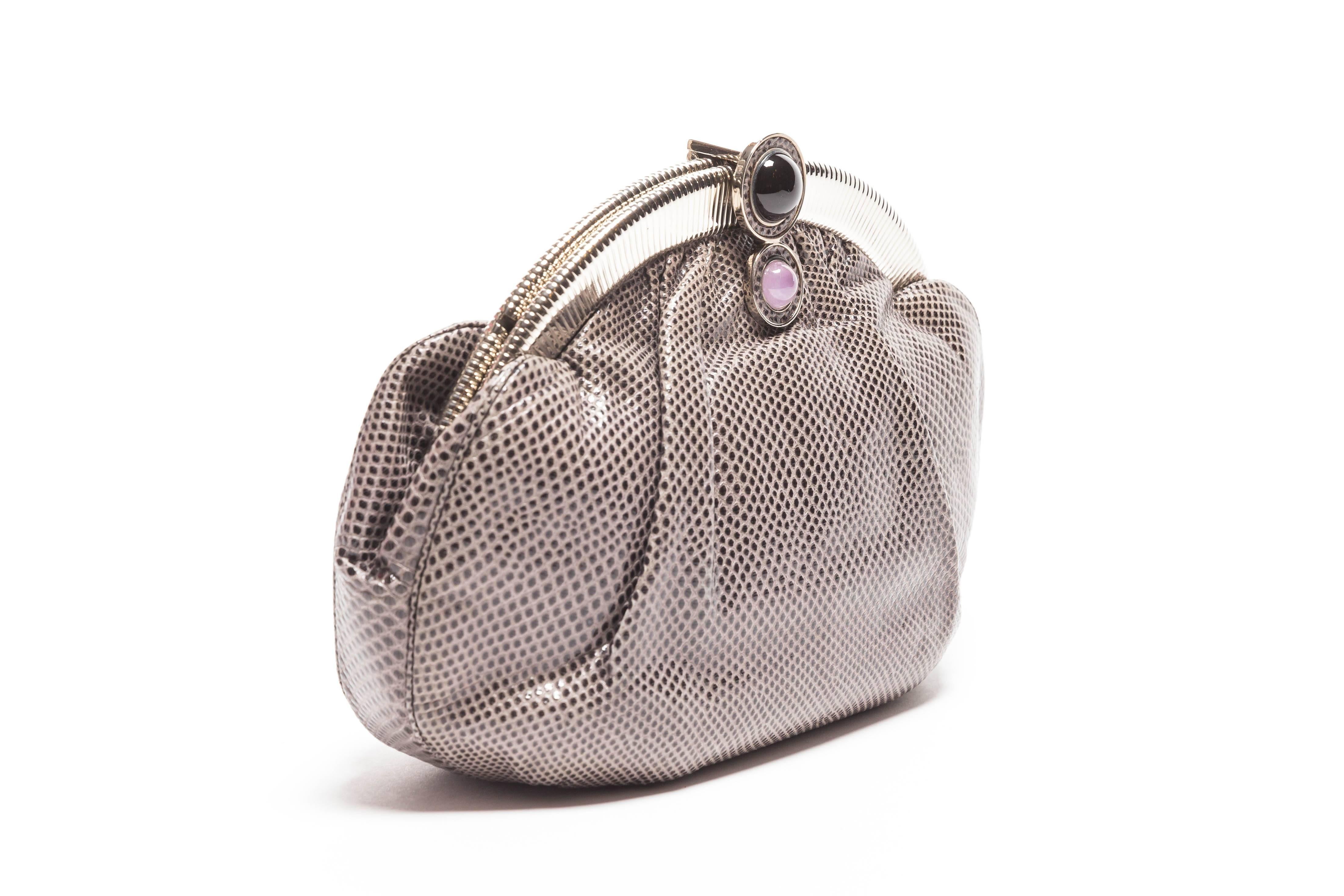 Very beautiful Judith Leiber graphite snakeskin clutch with silver trim and hidden silver shoulder chain.
Pink quartz and onyx cabochon stones accent the bar closure / opener of this bag.
Includes Judith Leiber change purse and comb.
Change purse
