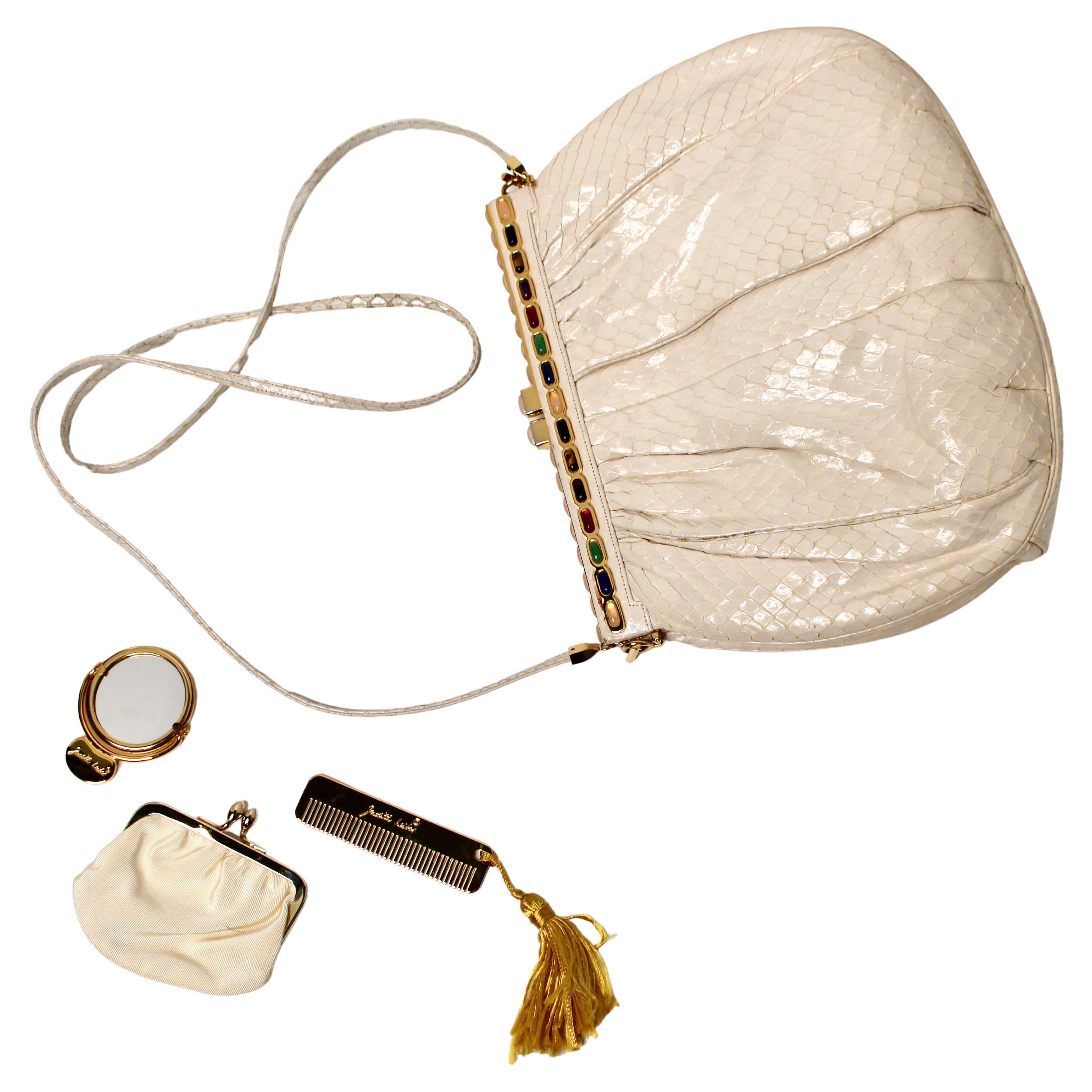 La pochette in pelle di serpente avorio Judith Leiber con tracolla, risalente agli anni '80 circa, è uno splendido esempio di artigianato di lusso vintage. Realizzata in squisita pelle di serpente color avorio, questa pochette emana eleganza e