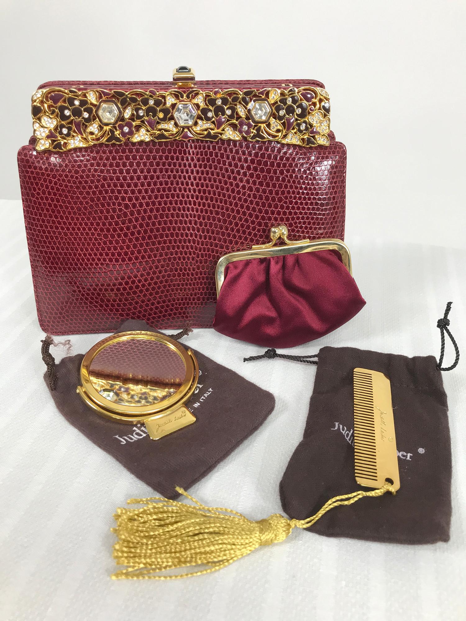 Judith Leiber jewel clasp, burgundy lizard clutch or shoulder bag with accessories, comb, mirror and change purse including protector bags and box. The bag is in beautiful condition, barely used. The frame is gold metal with shades of burgundy