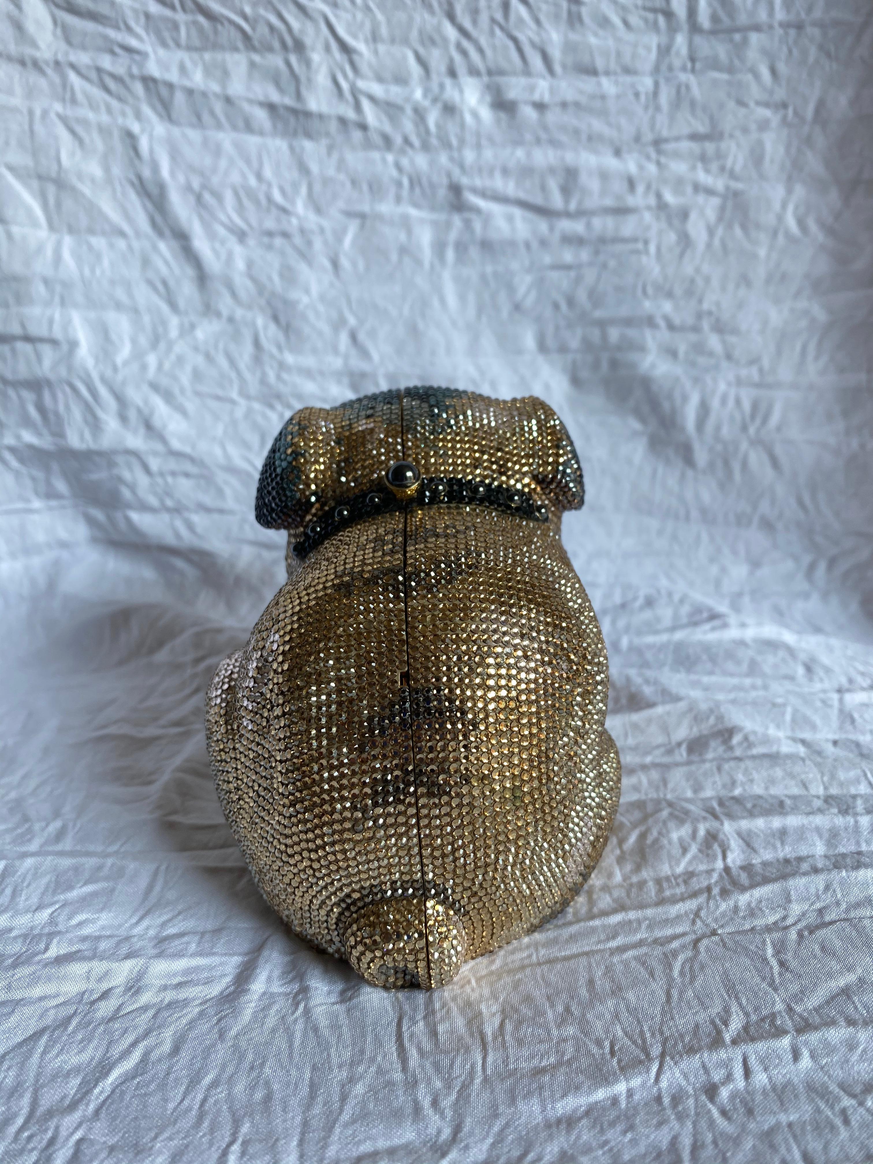 Shades of gold, silver, brown and black swarovski crystals decorate the gold-tone body of this Leiber minaudiere. In the shape of a dog, the bones of this design were inspired by Barbara Bush’s dog Millie. New with tags, originally