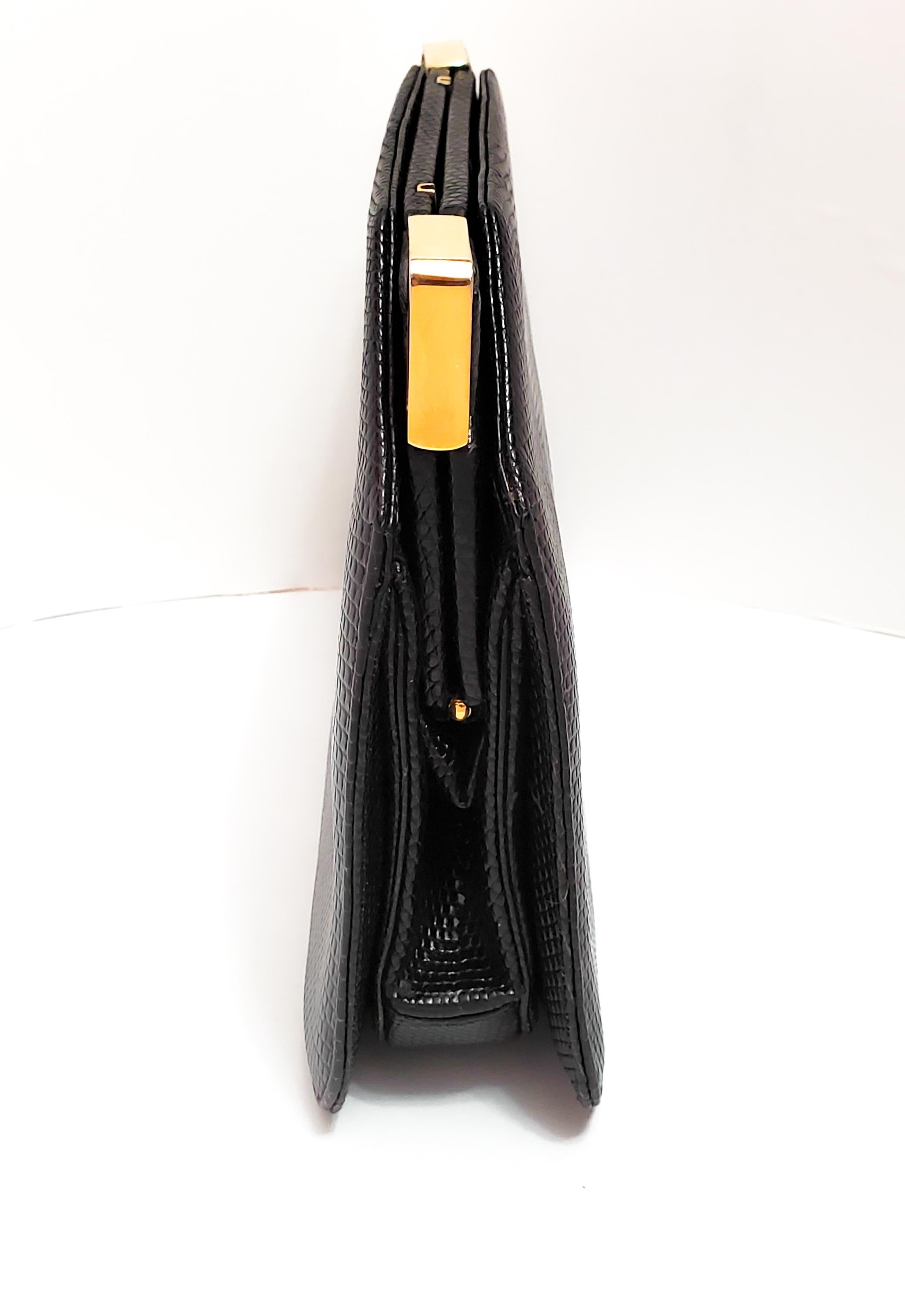 Judith Leiber is known world wide for her collectable handbags!  This fabulous example in black lizard features two art deco corner clasps with gold tone hardware.  Inside find a round mirror, a slash pocket and a zipper compartment with tiny purse