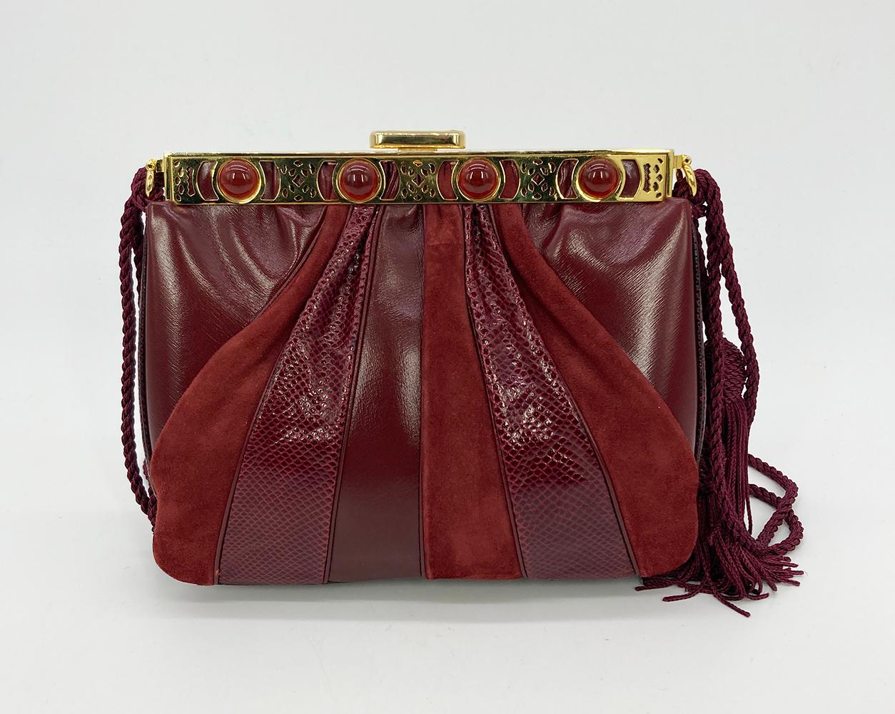 Judith Leiber Maroon Leather Suede and Lizard Tassel Strap Shoulder Bag in excellent condition. Unique tri leather exterior with maroon smooth calfskin, suede and lizard leathers trimmed with gold hardware and red gemstones along top edge. Silk cord
