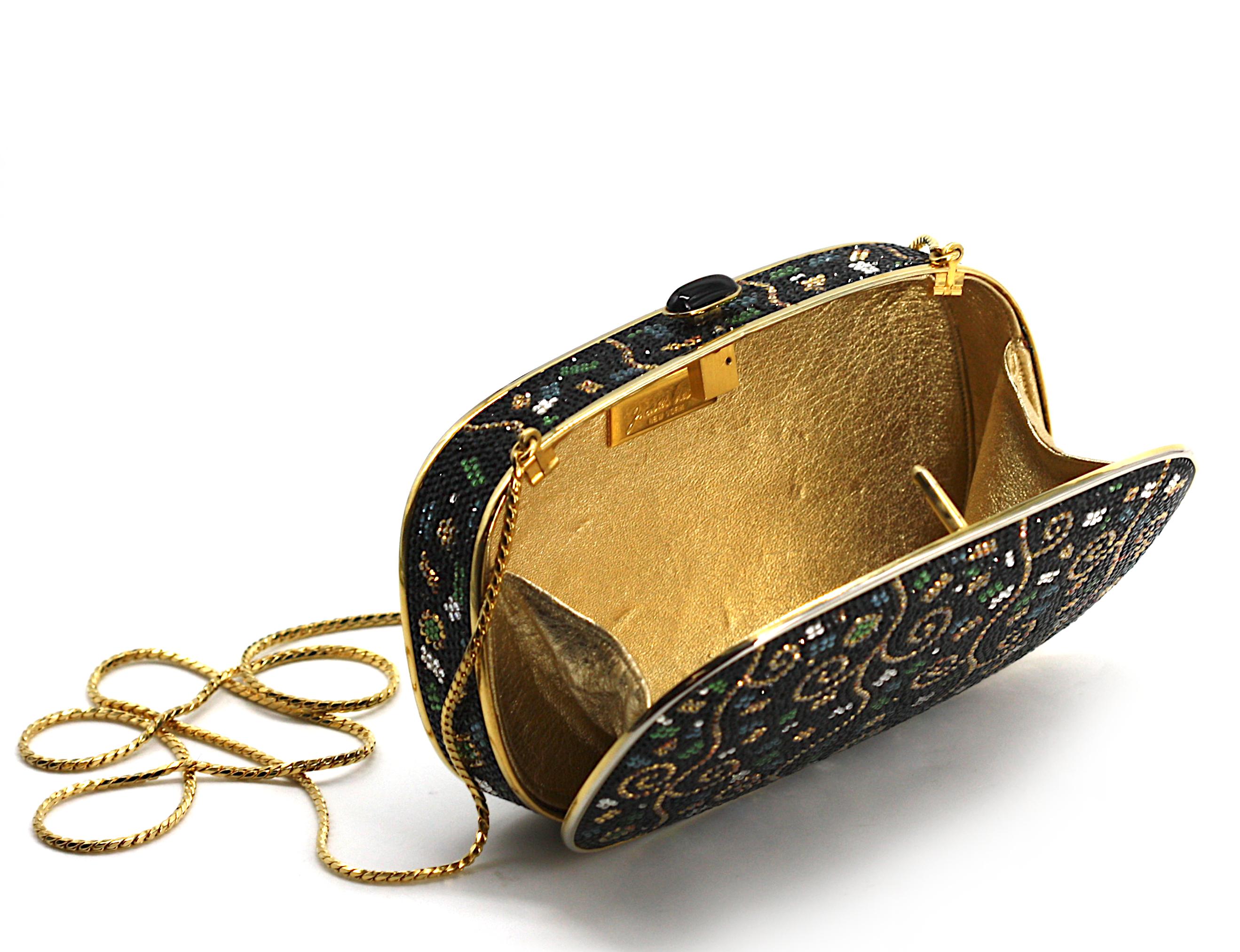 
Judith Leiber Minaudiere Evening Bag
The rounded rectangular bag with a stylized design of geometric devices and tendrils on a black ground, with a gilt-toned chain, and gilt fabric change purse.
Height 4.5 in., Width 6.5 in.
Condition Report
Good