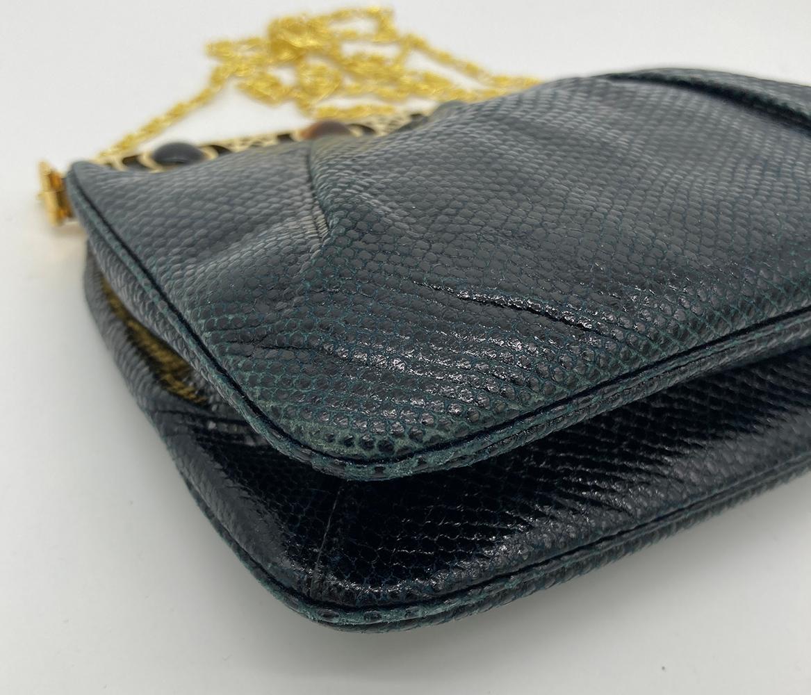 Judith Leiber Navy Blue Lizard Gemstone Top Shoulder Bag in good condition. Navy lizard exterior trimmed with gold hardware and multi color gemstones along top edge. Center lift latch closure opens to a black satin interior with two side slit