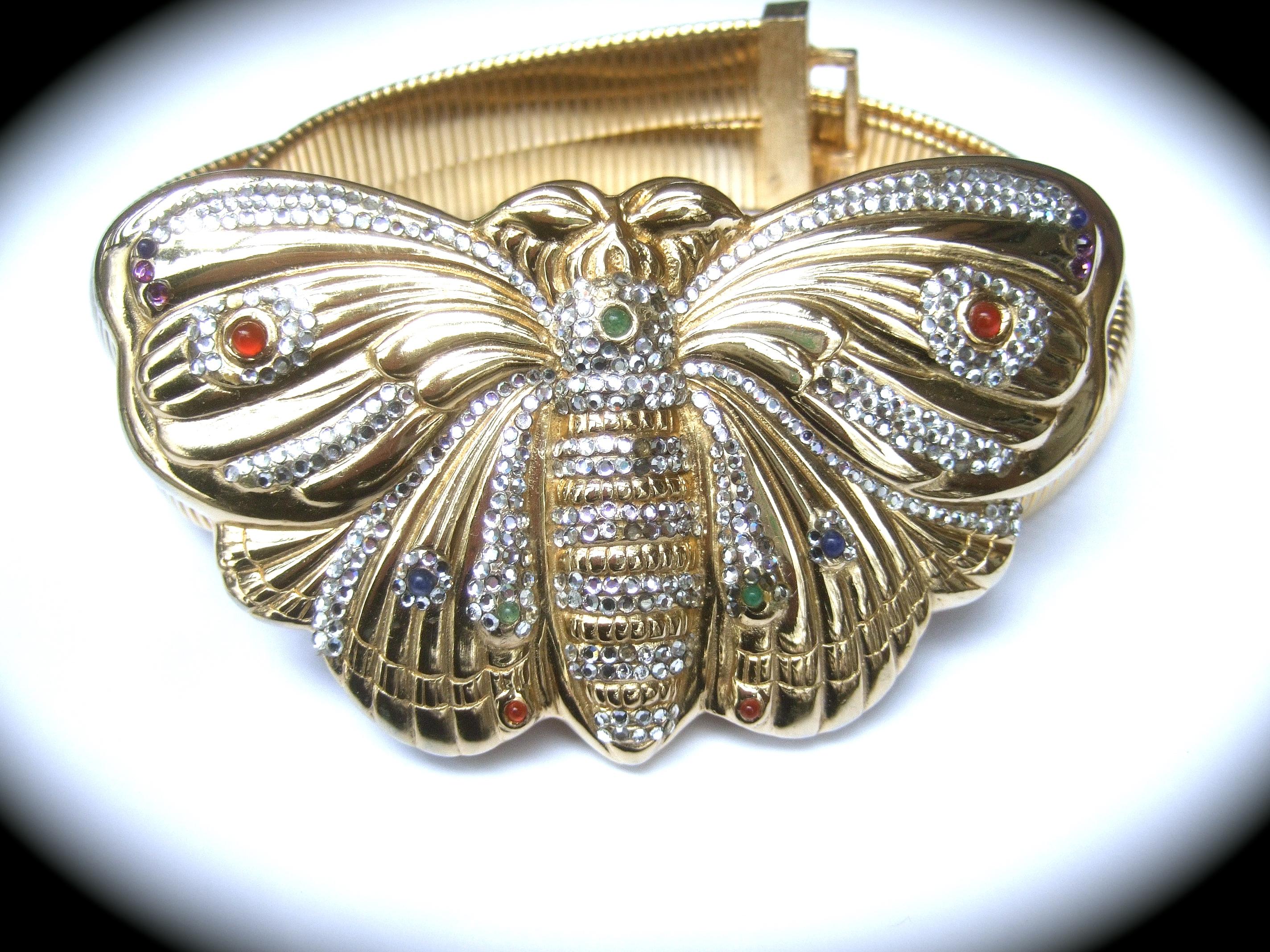 Judith Leiber Opulent crystal encrusted large scale gilt metal butterfly belt c 1980s
The massive gilt metal butterfly buckle is embellished with rows of intricate diamante crystals
Accented with jewel-tone small glass cabochons 

The massive