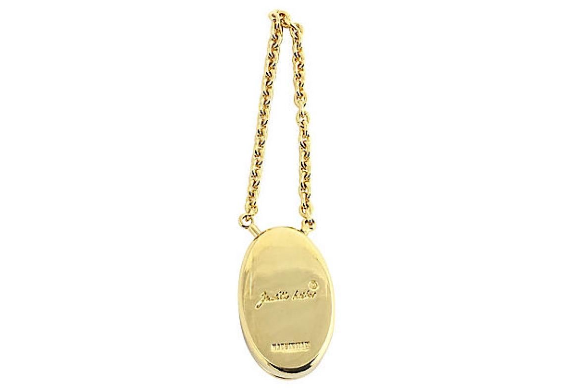 Judith Leiber goldtone metal perfume keychain with a carnelian accent. Turn-lock closure. Marked: Judith Leiber. Chain: 4.75