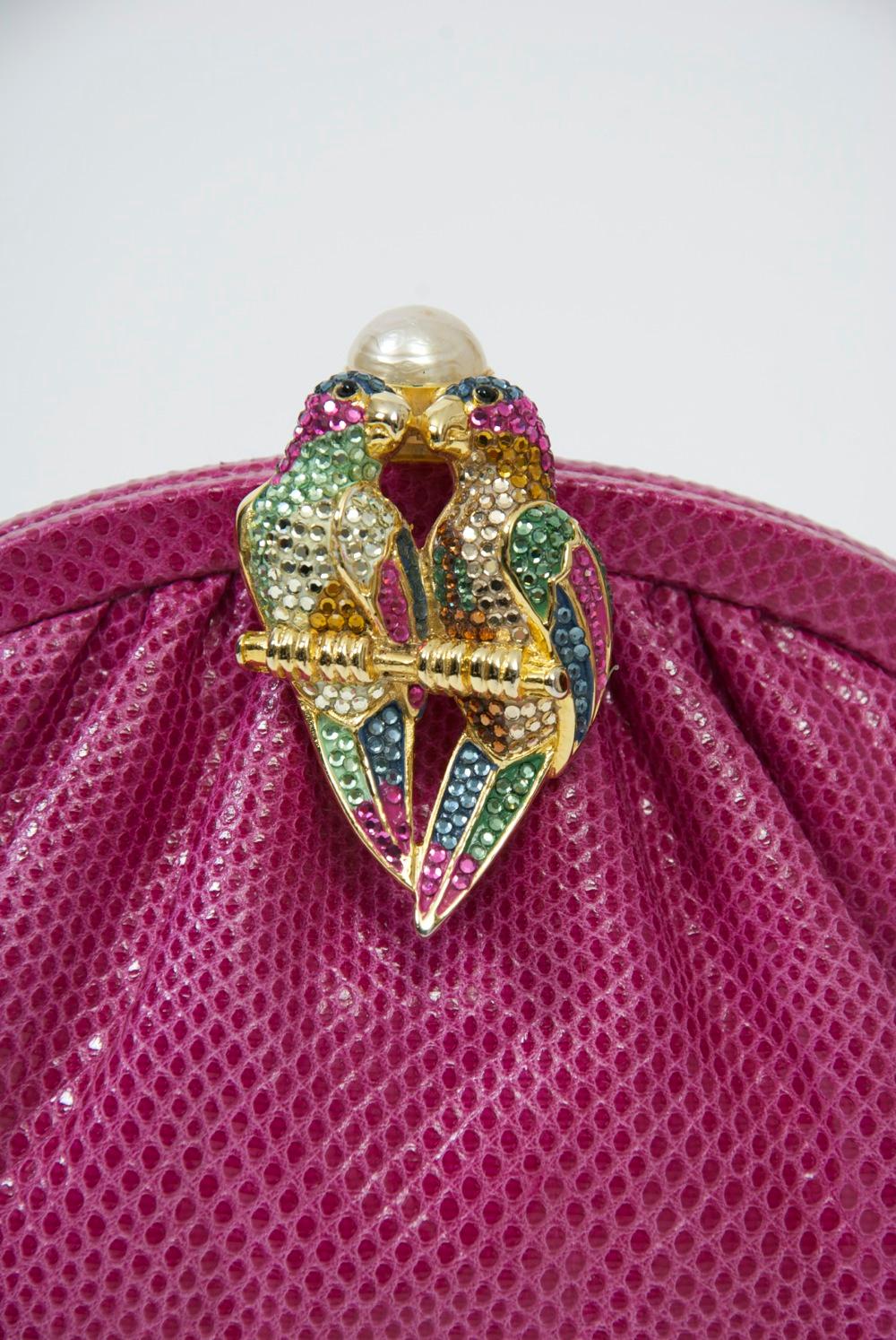 Judith Leiber convertible clutch/shoulder bag in a vibrant shade of pink karung featuring a double parrot clasp bejeweled with complementary crystals and topped with a large pearl. Matching fabric interior fitted with the usual Leiber accoutrments -