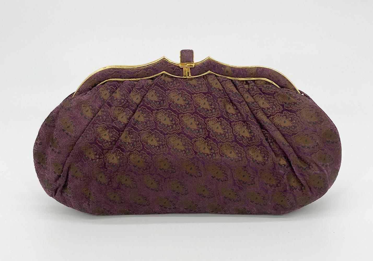 Judith Leiber Purple Embossed Suede Clutch in very good vintage condition. Purple suede exterior with unique gold and teal embossed print throughout and trimmed with gold hardware. Top lift latch closure opens to a purple nylon interior with one zip
