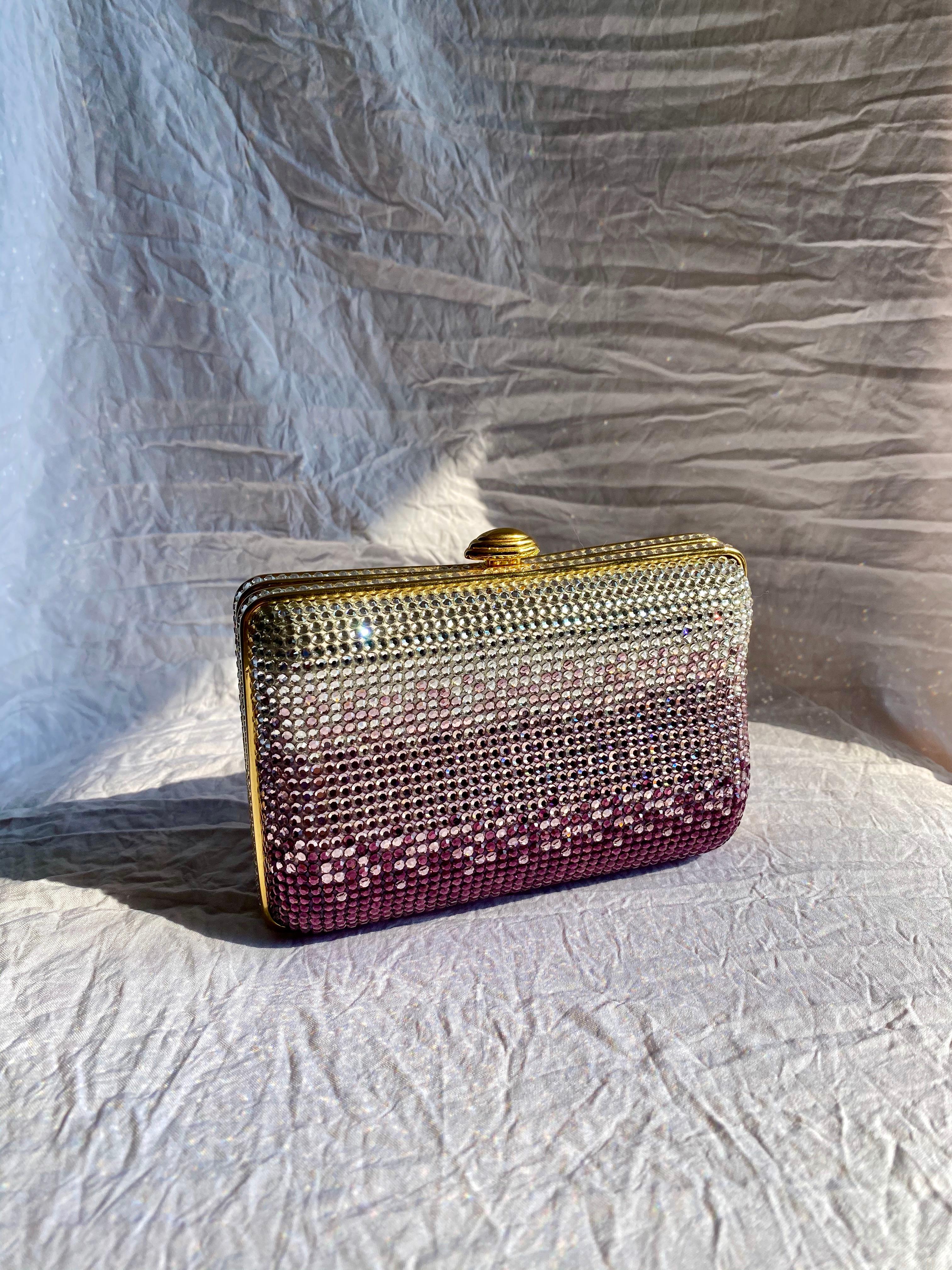 This bag features silver and tonal purple swarovski crystals, gold-tone hardware, a push lock clasp and a detachable rope chain. It comes new with tags, originally priced at $1,700.00, never used and in beautiful condition. 

Exterior: Missing some