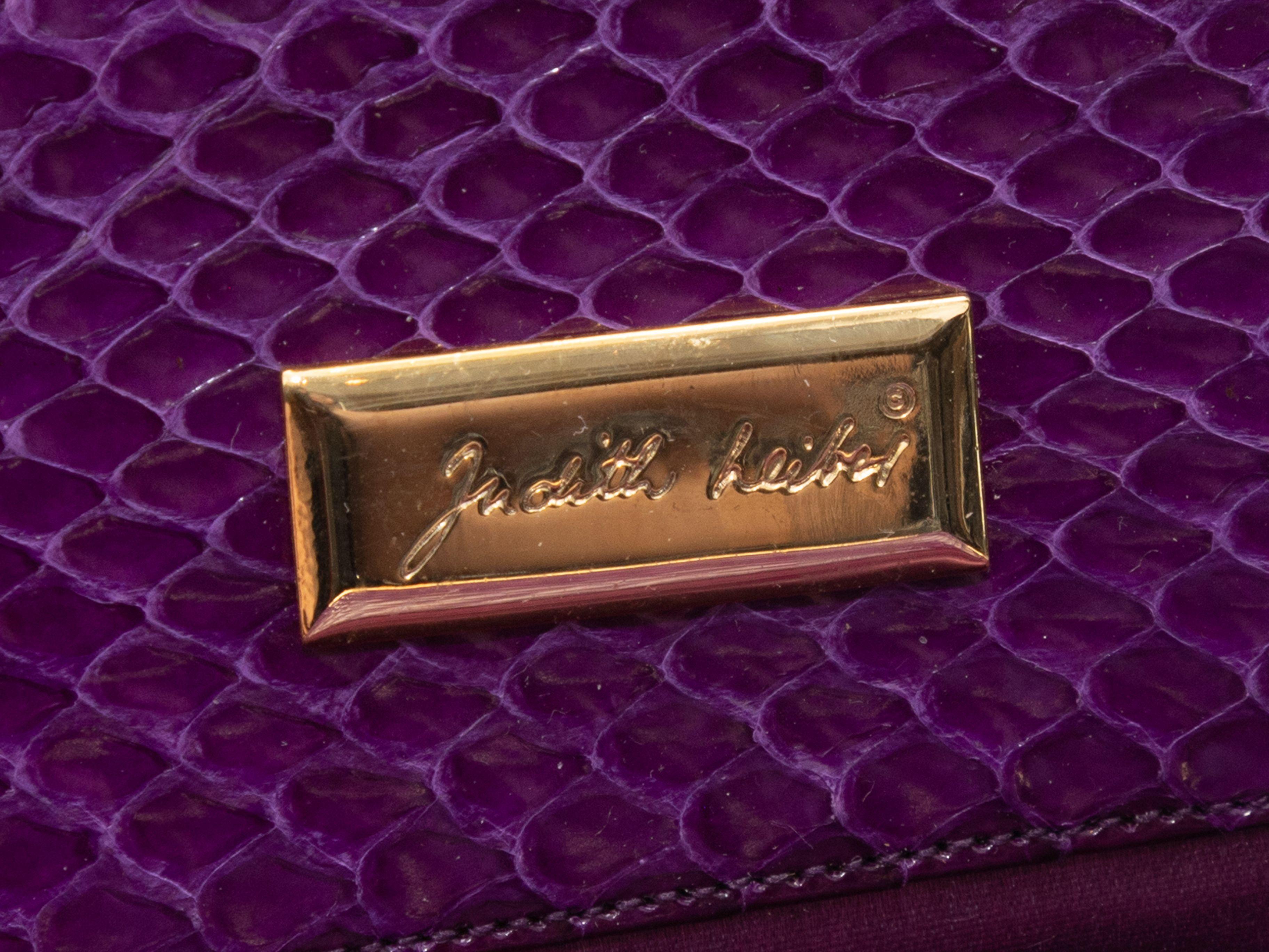 Product Details: Vintage Purple Judith Leiber Snakeskin Frame Clutch. This clutch features a snakeskin body, gold-tone hardware, purple satin interior, an optional shoulder strap, and a top cabochon clasp closure. 11