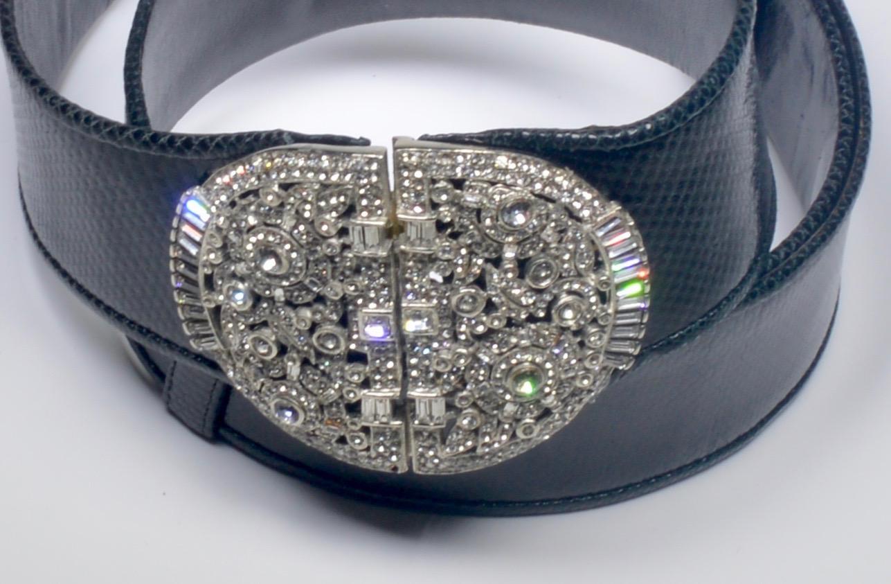 A stunning Judith LeiberBlack snakeskin belt,  with a silvertone rhinestone round buckle with a center hook closure.  Stamped inside Judith Leiber. 
The belt fits many waist sizes starting at 24