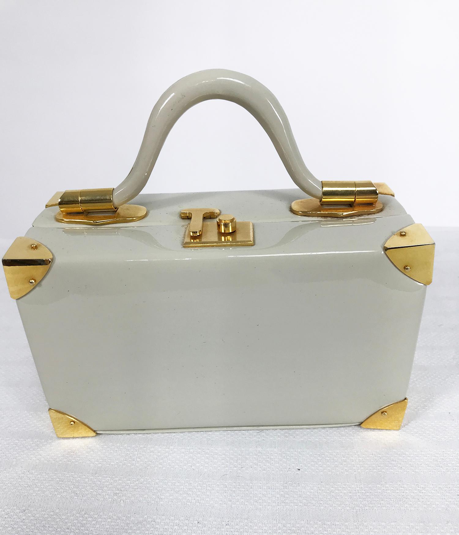 Judith Leiber rare 1960s taupe patent leather suit case, mini handbag. Trimmed in gold metal hardware, this small bag impersonates a suit case and was named so by Judith Leiber. Rigid curved handle with gold hardware, the bag has a brushed gold push