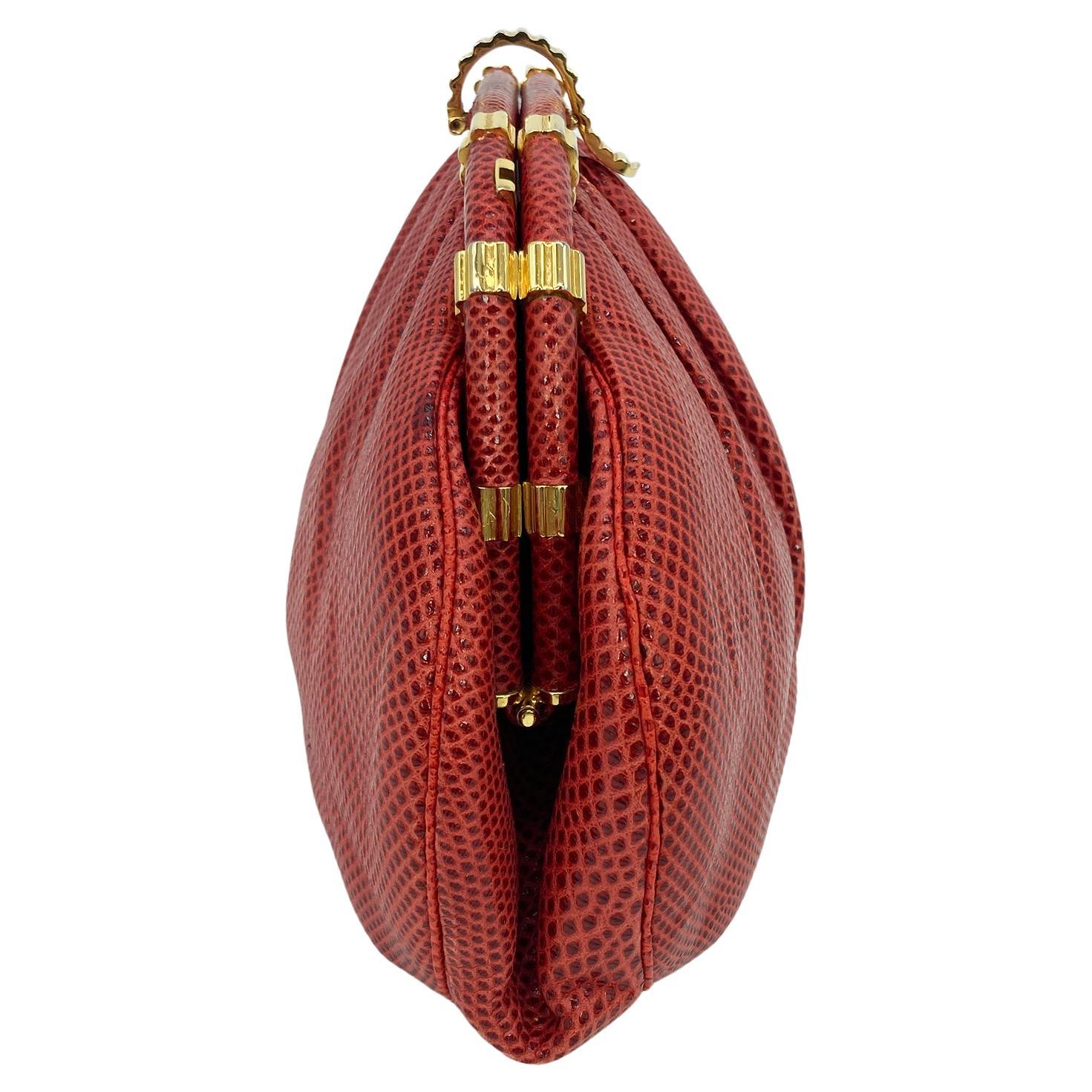Judith Leiber Red Lizard Clutch in good condition. red lizard leather trimmed with gold hardware. Lift latch closure opens to a red nylon interior with one slit and one zipped side pocket and attached matching red lizard shoulder strap. overall good