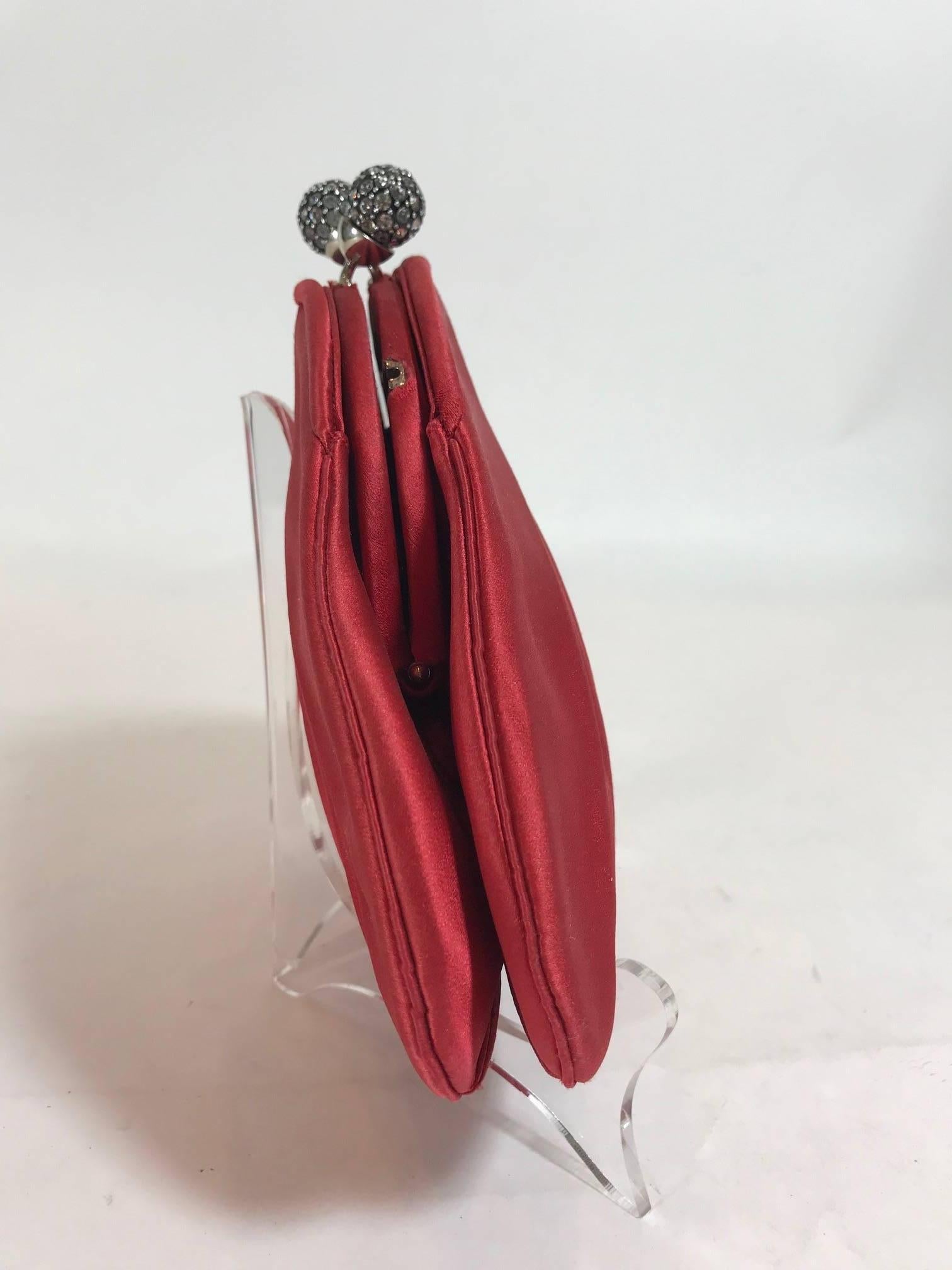 Red satin Judith Leiber evening bag enhanced by silver-tone hardware and a rhinestone encrusted kiss closure clasp. Red satin interior. Original Shoulder Strap included.
