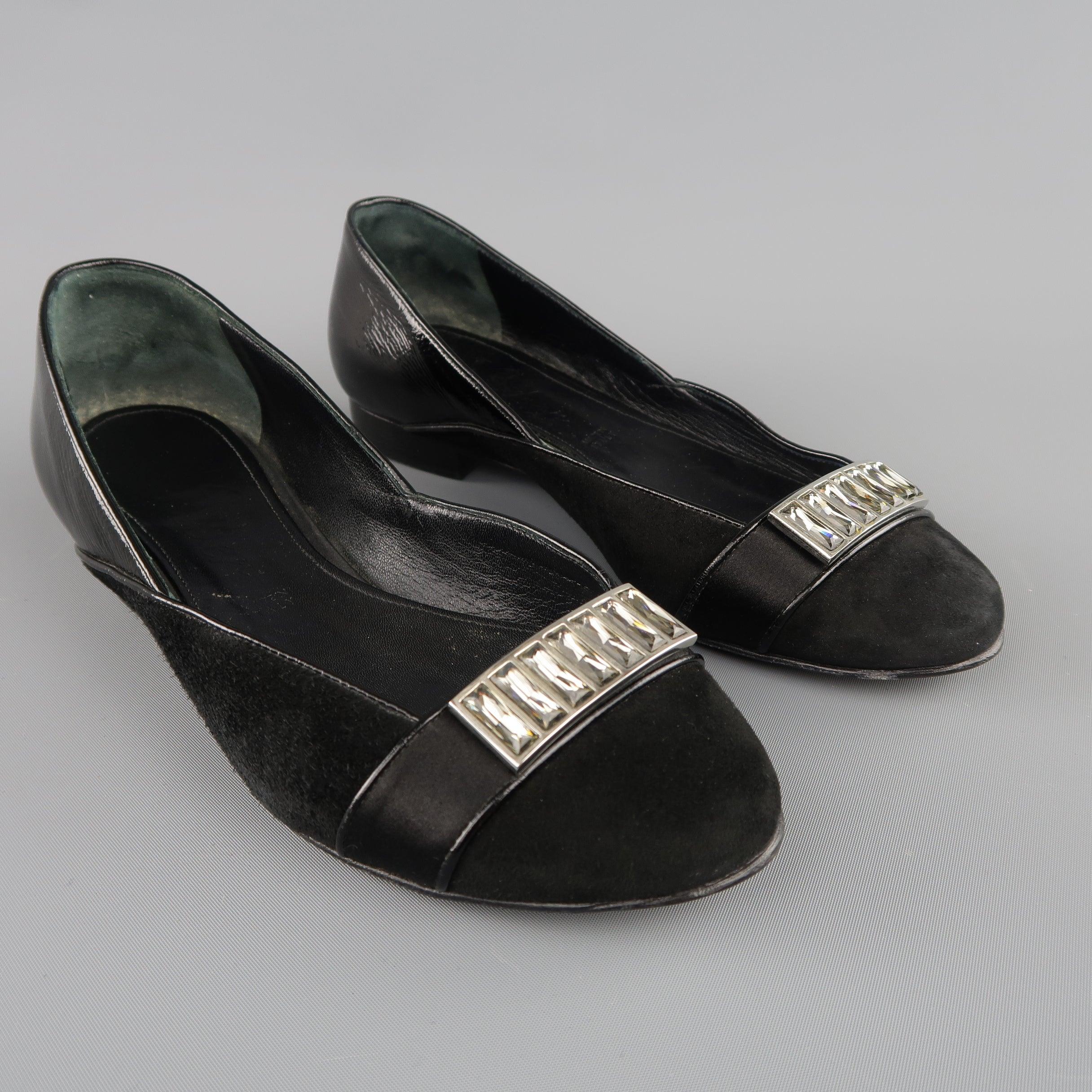 JUDITH LEIBER flats come in black suede and feature a patent leather heel panel, and satin strap detail with rhinestone brooch applique. Made in Italy.
Good Pre-Owned Condition.
 

Marked:   5 B
l	Outsole: 9 x 3 inches 

  
  
  
 
Reference:
