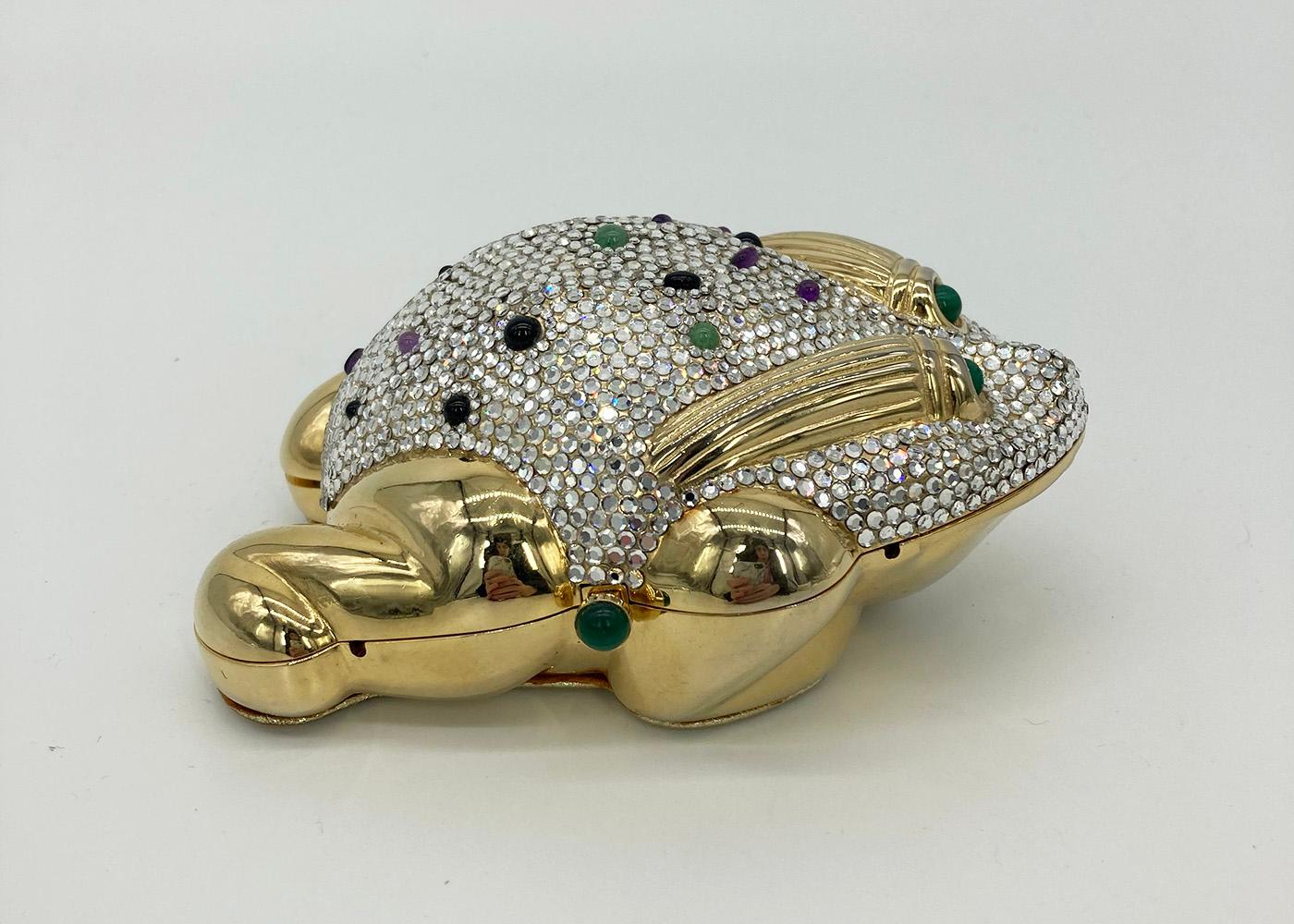 ADORABLE JUDITH LEIBER gold frog minaudiere in excellent condition.  Gold frog exterior with clear silver swarovski crystal body with multi color precious gemstones throughout.  Solid gold legs, bottom half and eyes. gold leather base. Side button