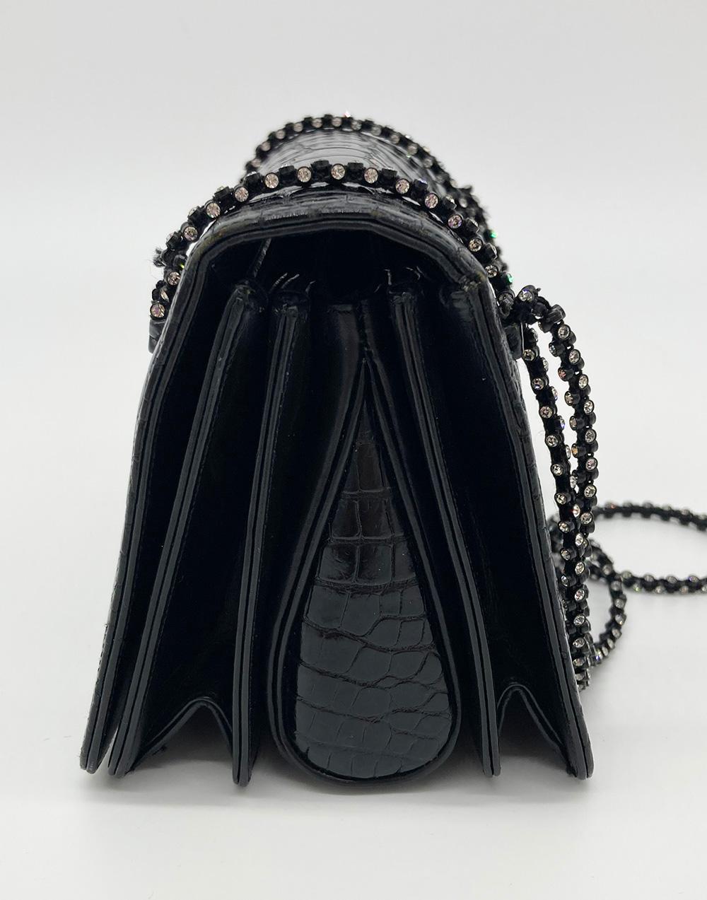 Bolso de noche vintage Judith Leiber con correa de cristal de aligátor negro en muy buen estado. Exterior repujado en cocodrilo negro adornado con correas de asa con cordones de brillantes estrás. El cierre frontal con solapa a presión se abre a un