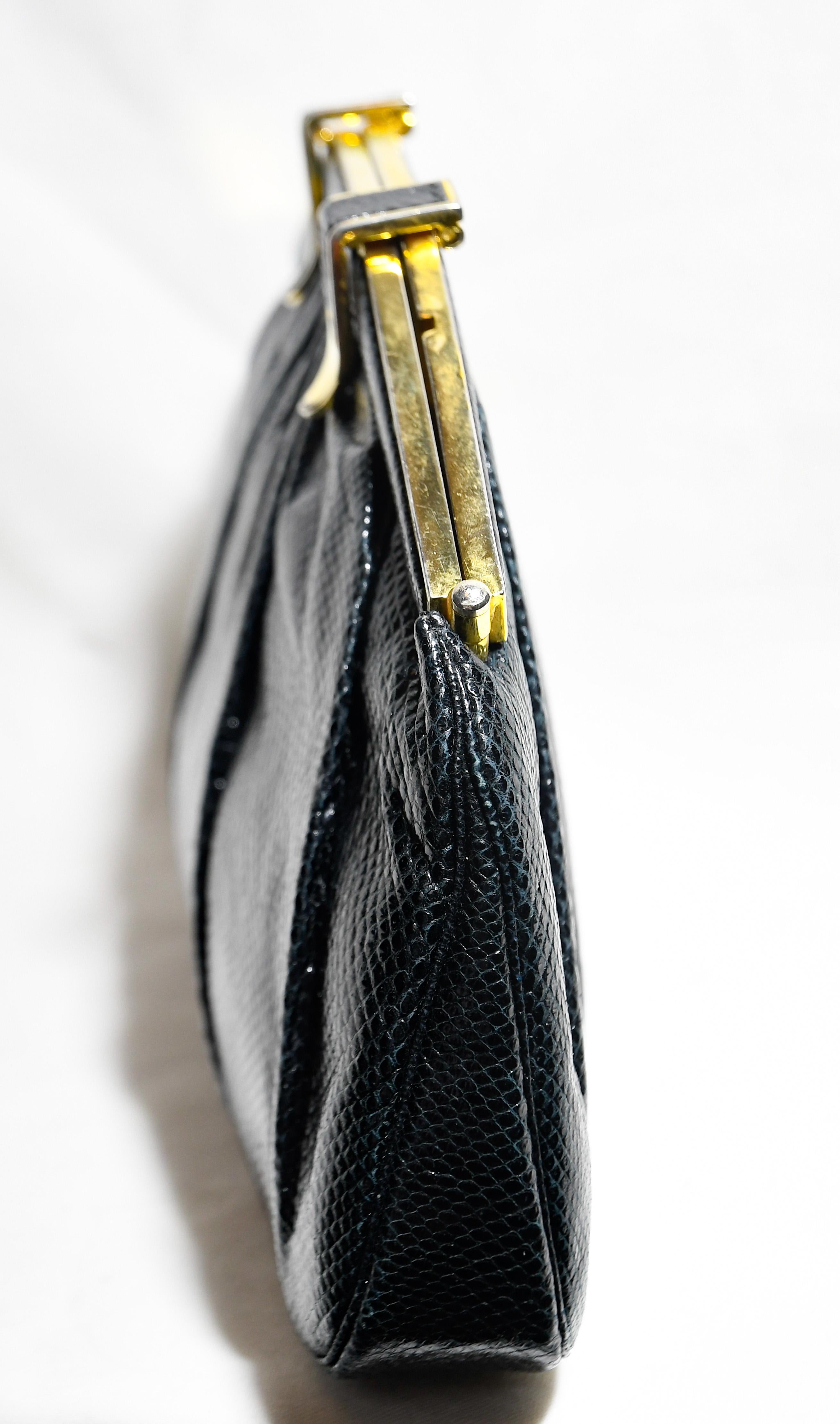 Judith Leiber vintage black lizard clutch incorporates an expandable opening frame with the two flip clasps for easier accessibility to the interior.  This interior compartment is lined in black satin that contains one side slit pocket and one