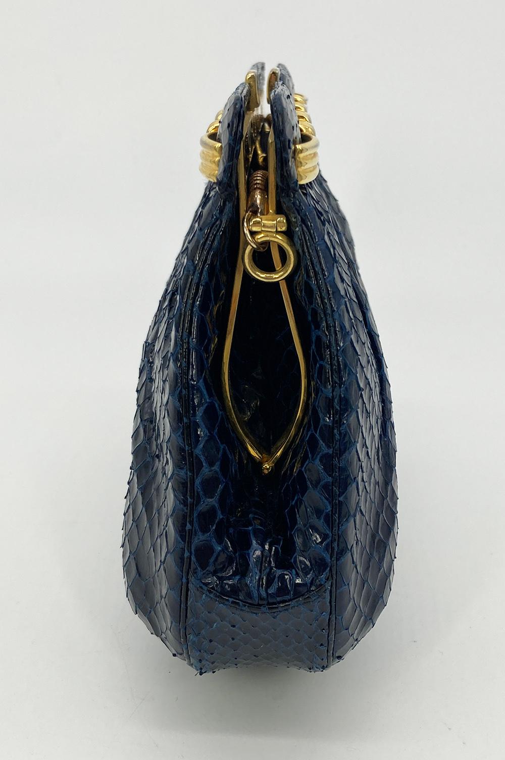 Judith Leiber Vintage Navy Snakeskin Clutch in very good condition. Navy snakeskin trimmed with gold hardware. Top kiss lock closure opens to a navy nylon interior with 2 side slit pockets. Overall very good condition. clean corners edges and