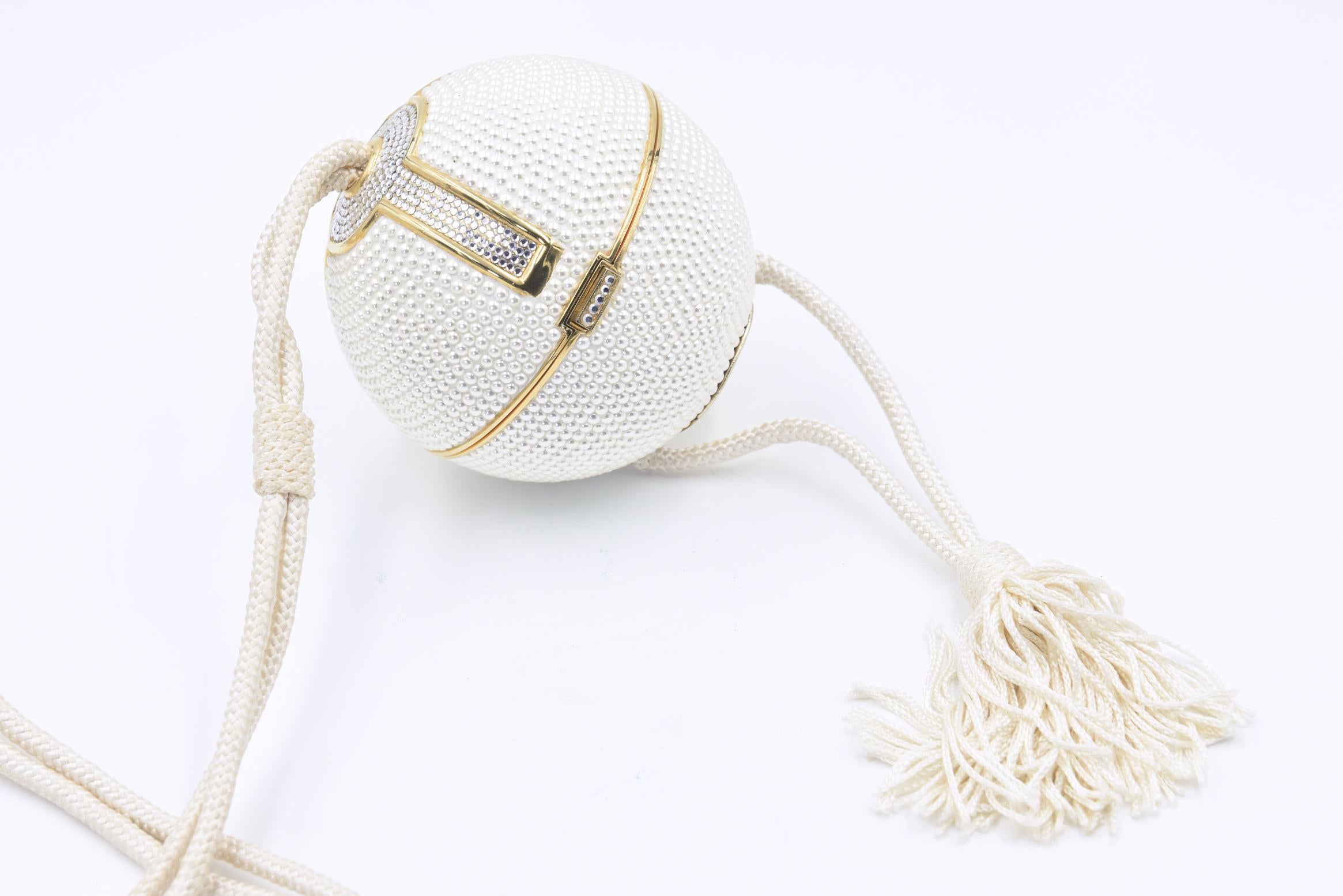 RARE Judith Leiber white crystal sphere minaudières shoulder bag in excellent vintage condition. White Swarovski crystal exterior trimmed with gold edges and clear crystals along top and side design. Corded Silk shoulder strap with tassel detail.