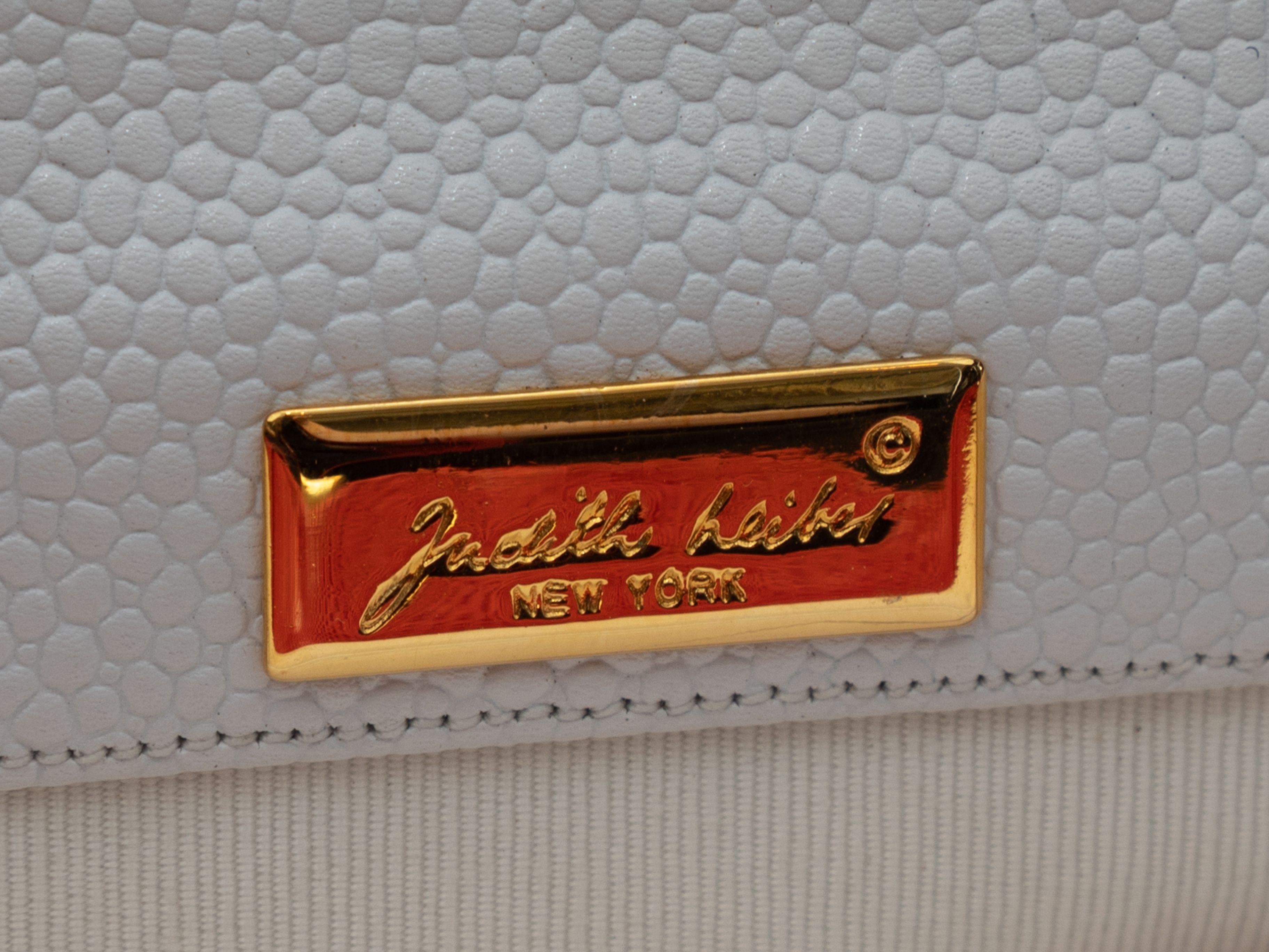 Product Details: White & Red Trim Judith Leiber Leather Shoulder Bag. This bag features a leather body, lizard skin trim, gold-tone hardware, a grosgrain interior, a front buckle accent, and dual flat shoulder straps. 12.25