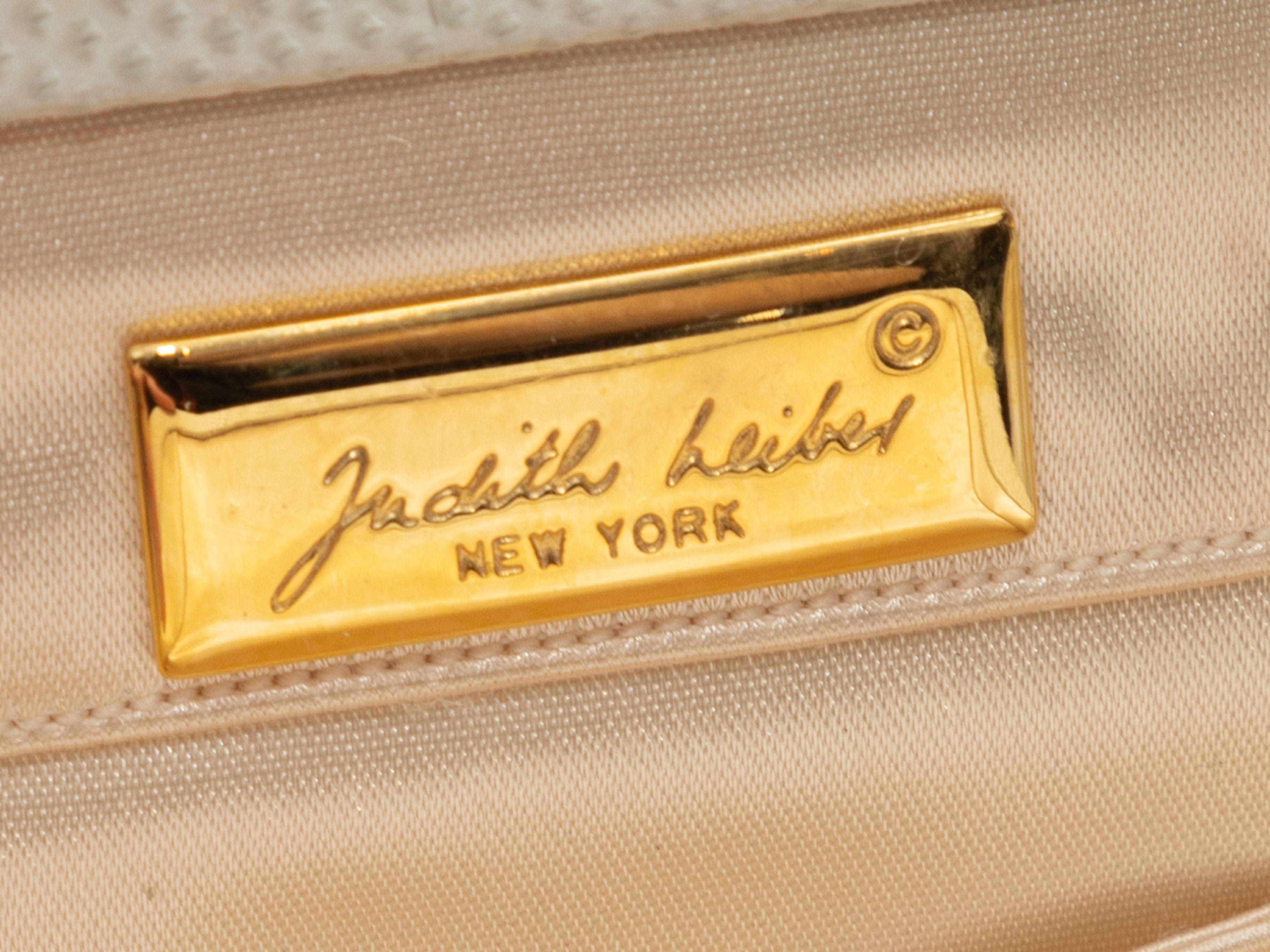Product Details: Vintage White Judith Leiber Lizard Frame Clutch. This clutch features a lizard skin body, gold-tone hardware, an optional shoulder strap, and a top bow clasp closure. 8.5