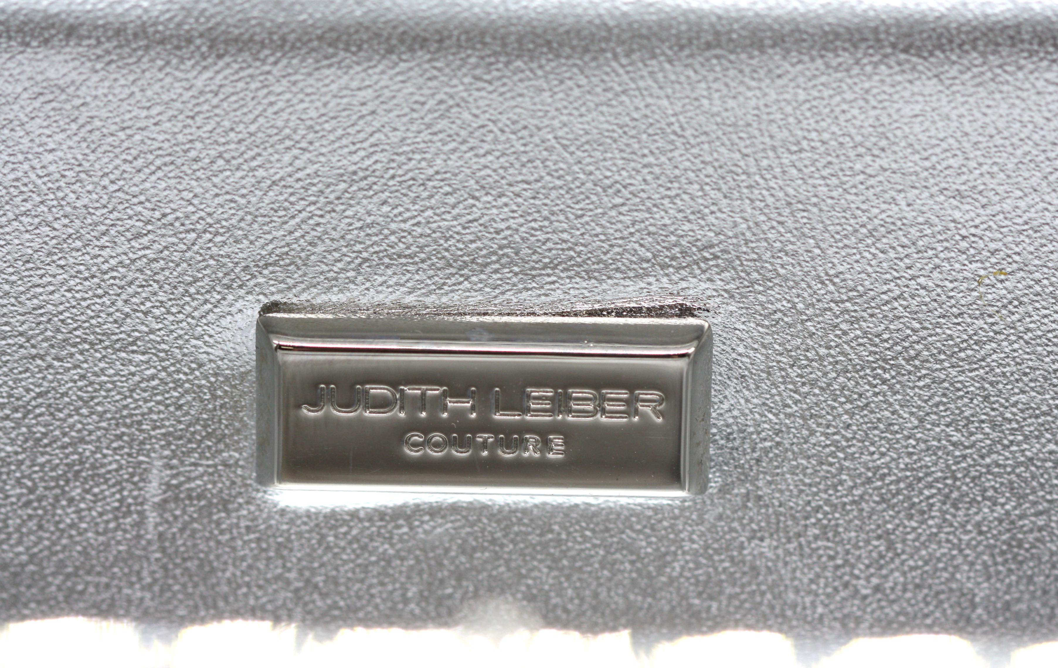 Judith Leiber Black Minaudière Evening Bag

A sophisticated rectangular minaudière by Judith Leiber, rendered in sleek black with silver-toned hardware. The bag features a refined sliding clasp and a luxurious silvered leather lining, combining