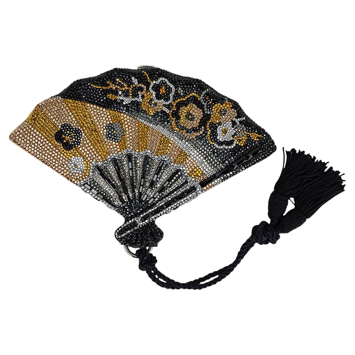 Judith Leiber Fan Minaudiere clutch bag featured in multicolored fine crystal.
Beautifully designed as Geisha fan, the bag has hand placed Swarovki Crystals in black, gold and silver.
The front and rear have a floral design at the top.
The