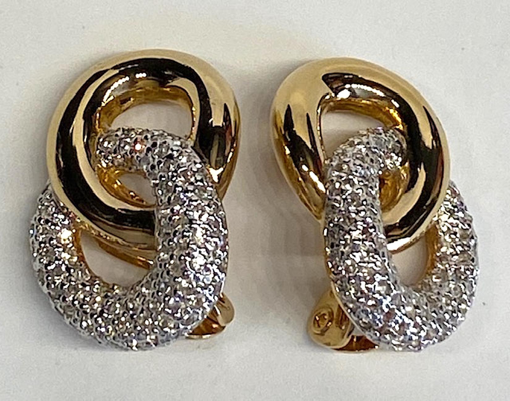 A lovely pair of 1980s Judith Leiber double link earrings in gold tone and pave' rhinestone. Each earring measures 1 inch wide, 1.38 inches high and .63 of an inch deep including the clip back. There is a right and left earring so each fits properly