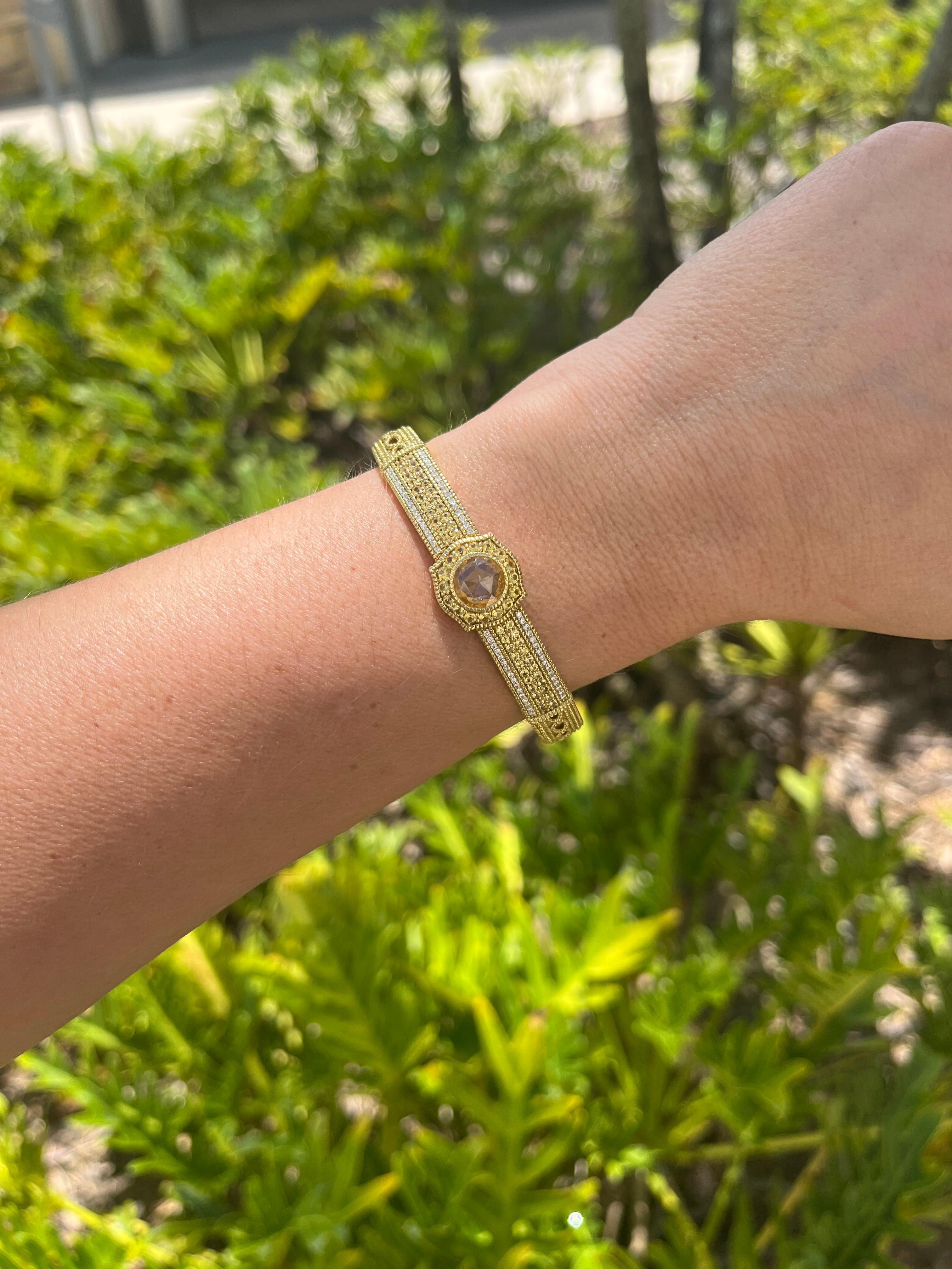 Elevate your jewelry collection with the timeless allure of the Judith Ripka 18k Yellow Gold Yellow Sapphire Bangle Bracelet. This exquisite piece exudes sophistication and luxury, designed to capture hearts and turn heads.

At its center, a