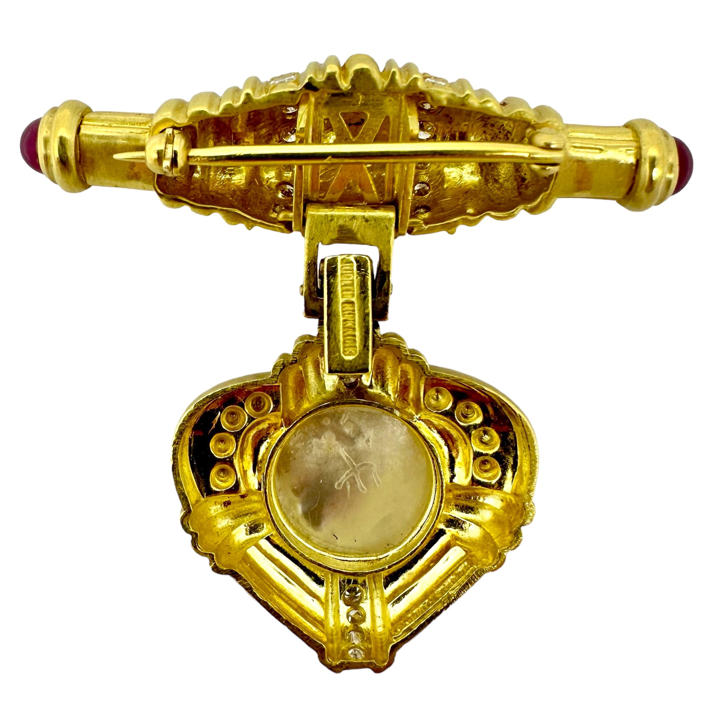 This 18K yellow gold Judith Ripka neo-classical style brooch features a two piece design. When combined together, the two pieces measure 2“ x 2“.  The pin at the top can be separated from the heart at the bottom simply by opening the flip clasp on