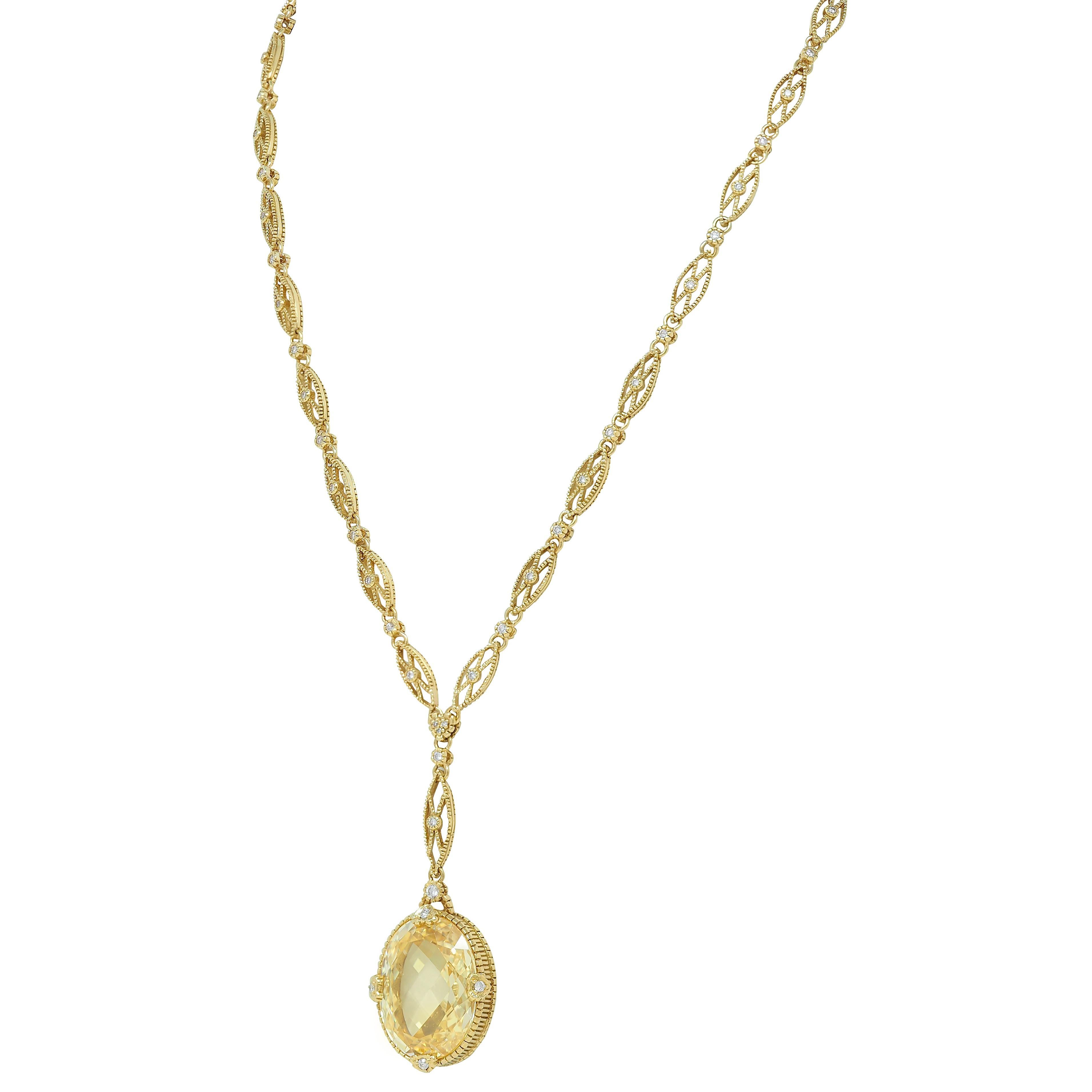Comprised of fancy marquise shaped link chain suspending a central drop station
Featuring an oval cut canary quartz crystal measuring 16.0 x 21.0 mm
Transparent pastel yellow in color - set with heart shaped prongs
With a fluted gold profile and