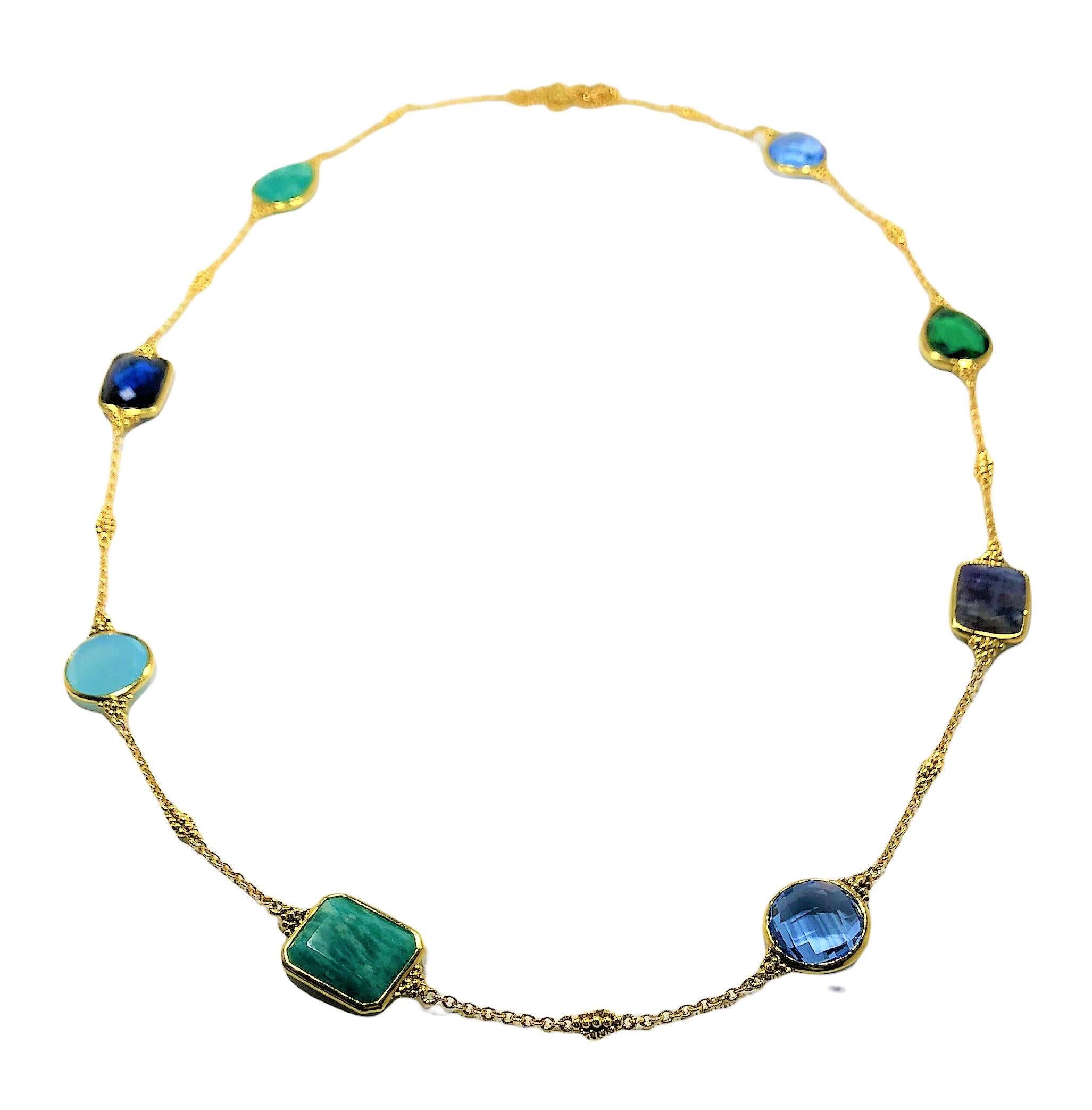 This stylish 34 inch long  18k yellow gold neck chain by Judith Ripka is bezel set with assorted, faceted,  natural and synthetic colored stones in various hues of green and blue.  All stones along the necklace's length range in size from  1/2 inch