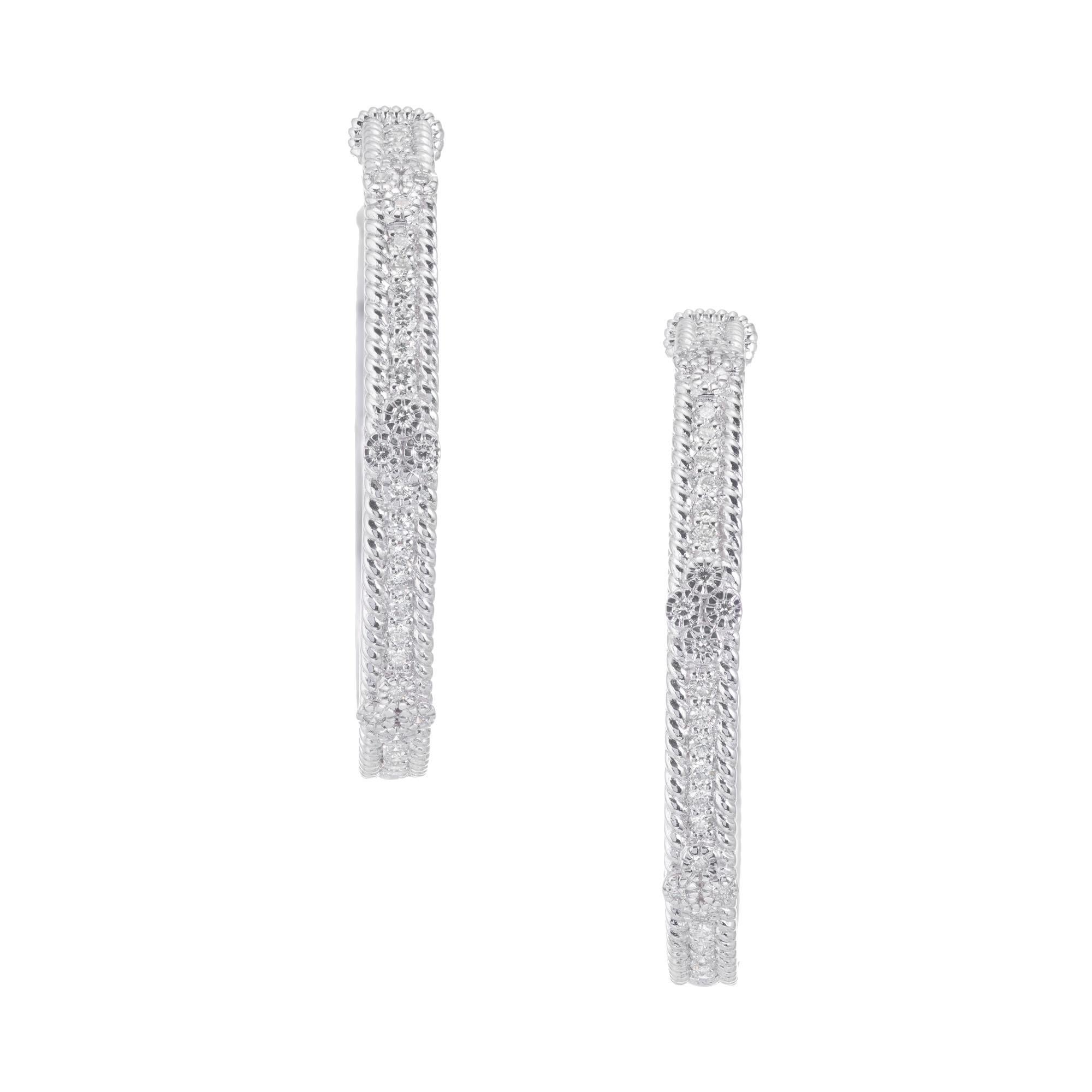 18k white gold Judith Ripka diamond hoop earrings with 24 round brilliant cut accent earrings.  

24 round brilliant cut diamonds, approx. .72cts
18k white gold 
Stamped: 18k
Hallmark: Judith Ripka
18.7 grams
Top to bottom: 39.7mm or 1.5 Inch
Width: