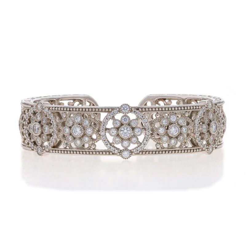 Brand: Judith Ripka

Metal Content: Sterling Silver

Stone Information

Cubic Zirconias
Cut: Round Brilliant
Color: Clear

Style: Cuff
Fastening Type: Hinged (hinge allows bracelet to slide over wrist)
Theme: Floral Medallion
Features: Open Cut