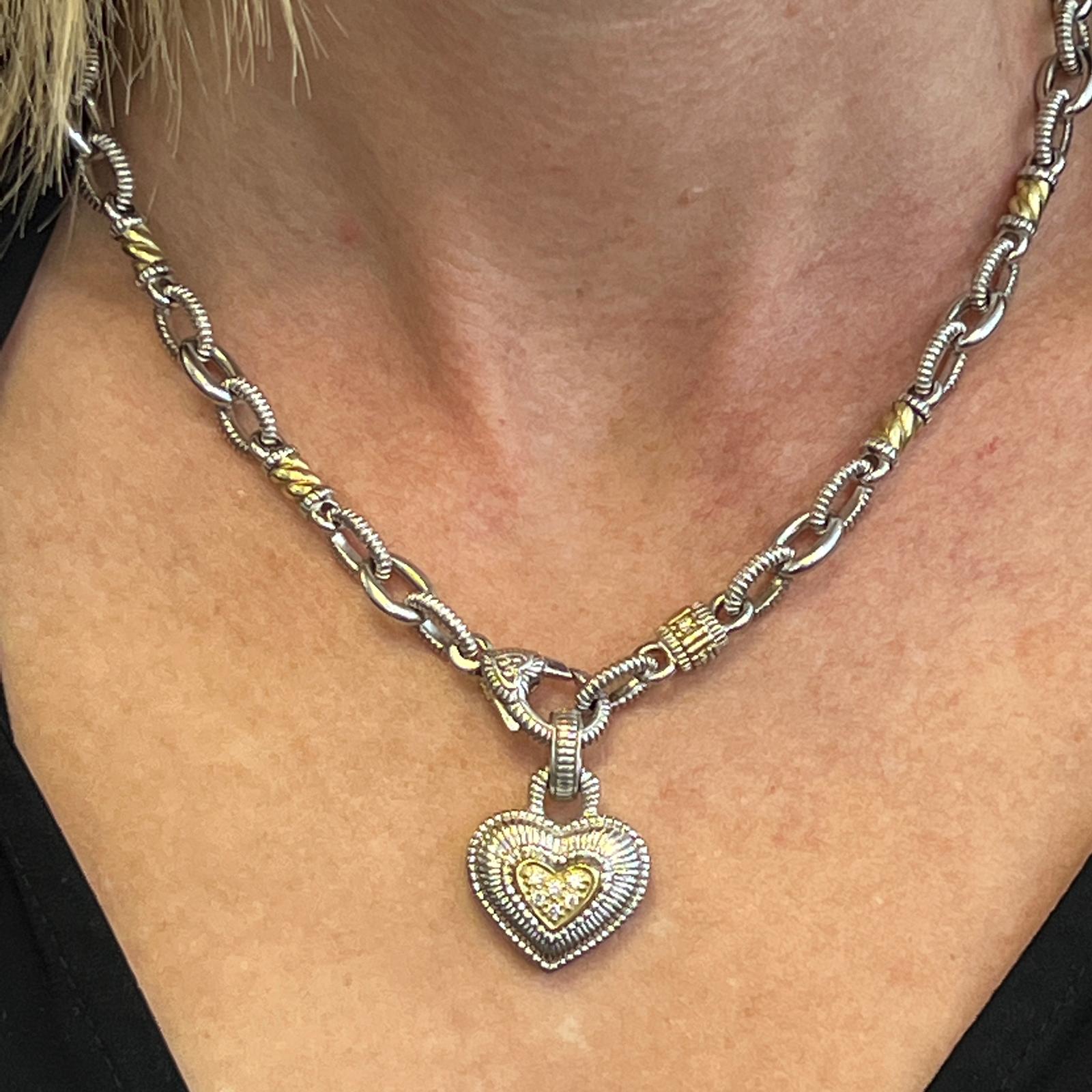 Diamond heart pendant necklace fashioned in 18 karat yellow gold and sterling silver by designer Judith Ripka. The necklace features 14 round brilliant cut diamonds weighing approximately .21 CTW. The detachable heart measures .90 x 1.0 inches, and