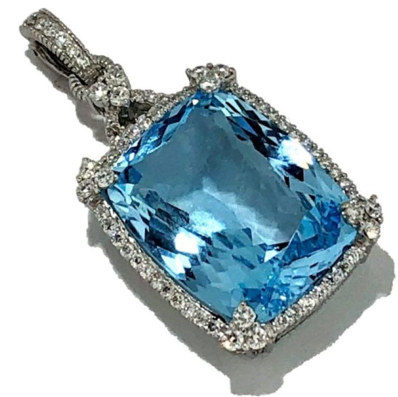 This intricately detailed and substantial Judith Ripka designer pendant has, at it's center, one cushion shaped, brilliant cut, shimmering natural blue topaz weighing exactly 36.83 carats. Surrounding this large center stone is a continuous line of