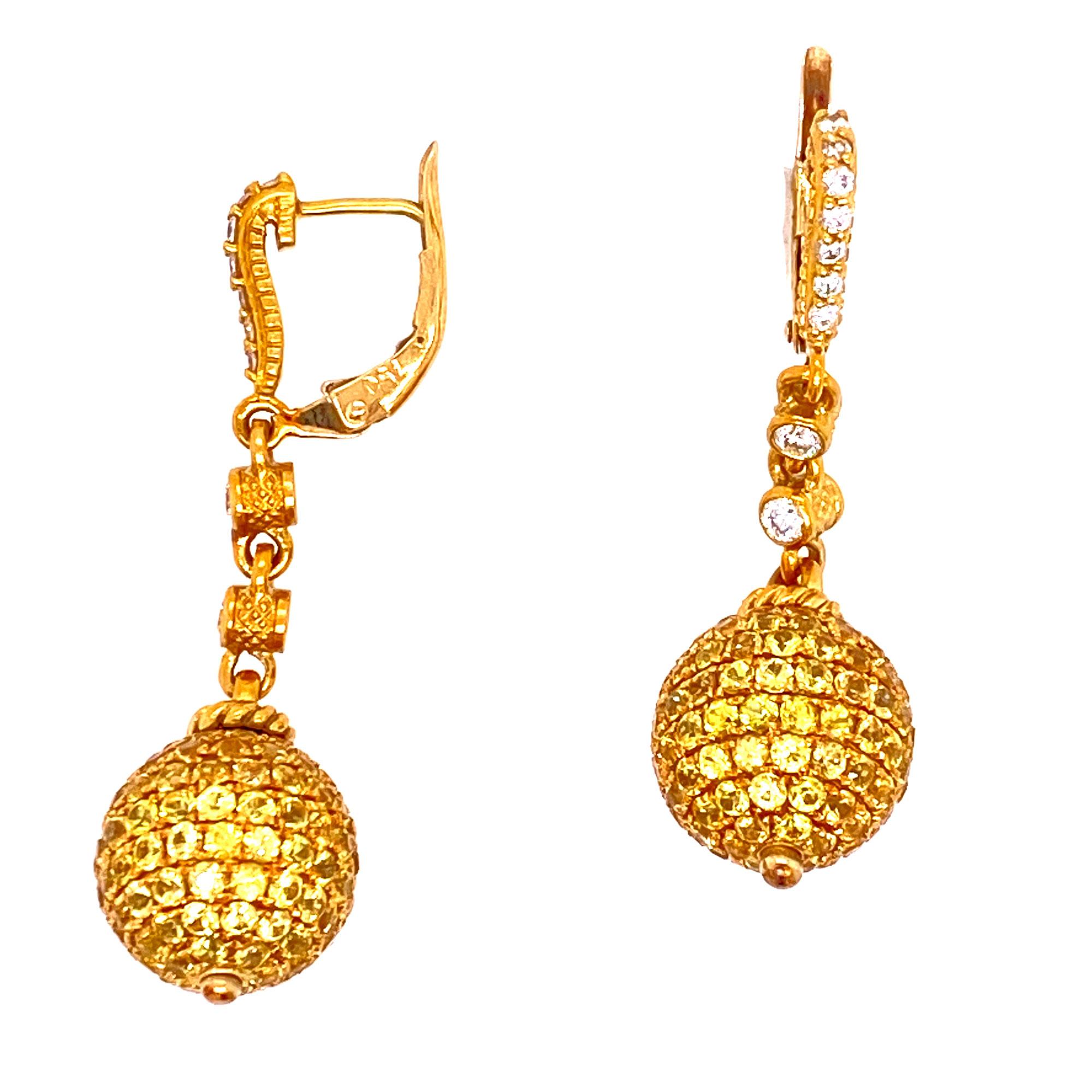 Yellow sapphire and diamond drop earrings by designer Judith Ripka. The earrings are fashioned in 18 karat yellow gold.  They feature .26 carats white round brilliant cut diamonds and large yellow sapphire encrusted ball drops. The earrings measure