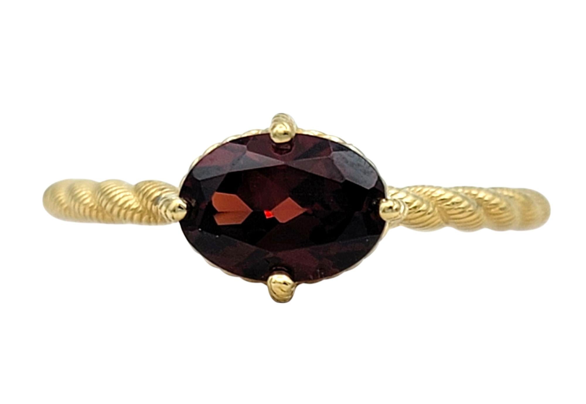 Misura dell'anello: 6

Questo anello di Judith Ripka presenta un granato incastonato a est-ovest in una fascia in oro giallo 14 carati dalla texture a corda. Il granato di forma ovale ha una tonalità rossa profonda e vivida che contrasta