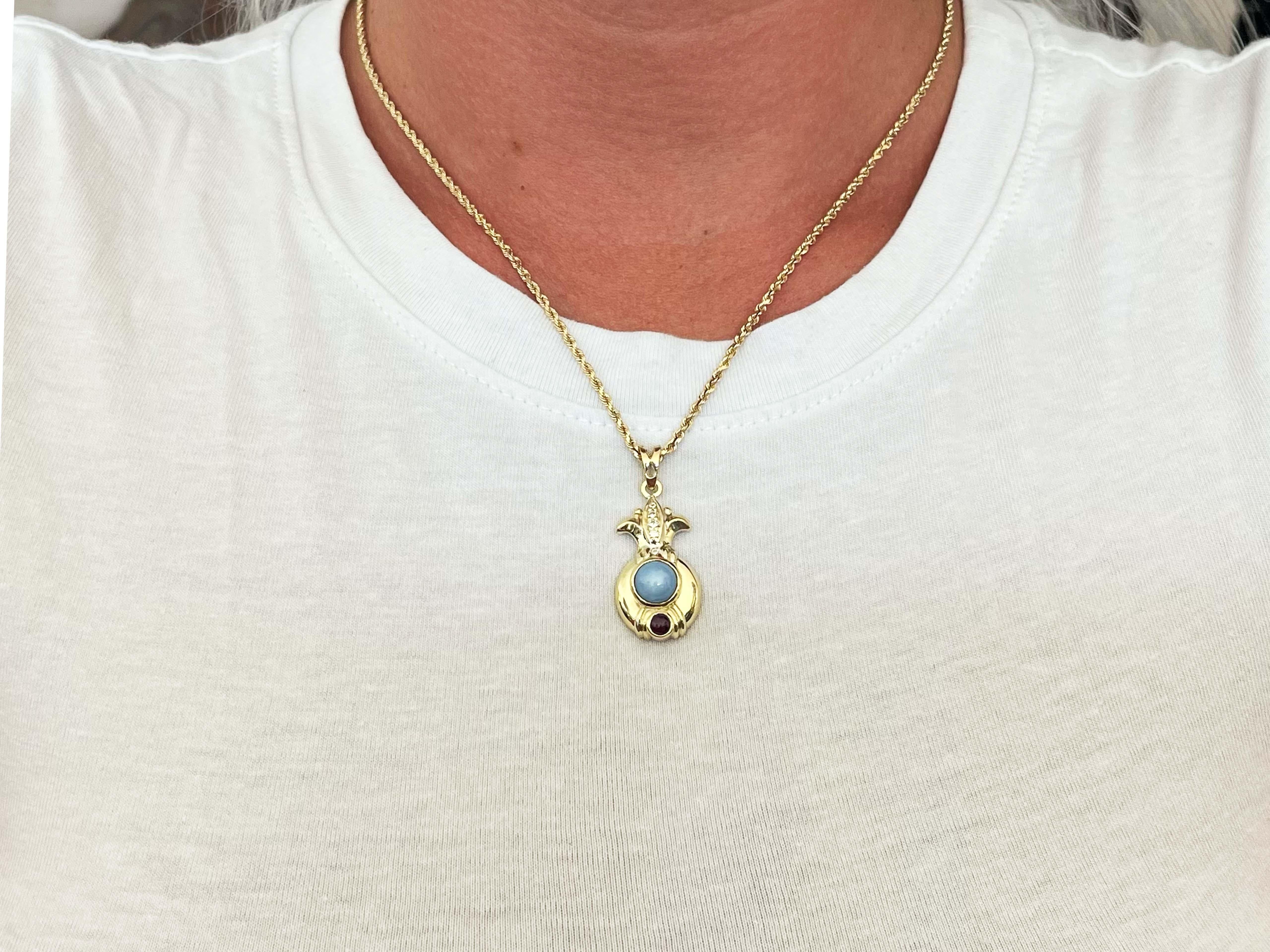 This beautiful vintage Judith Ripka pineapple pendant has gemstones running down, starting with 5 round diamonds then a baby blue star sapphire cabochon and ending off with a beautiful red ruby cabochon giving the piece versatility and making it one