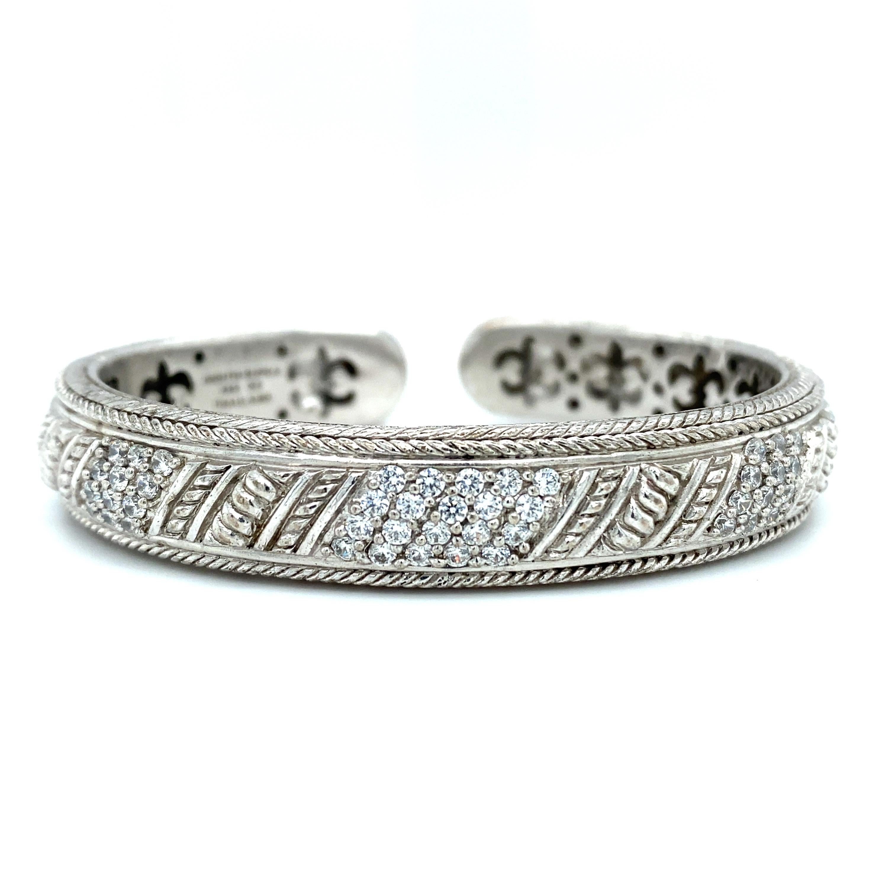 Artikel-Details: Dieses Armband mit Scharnier von Judith Ripka ist aus Sterlingsilber gefertigt und hat eine Seilumrandung mit CZ-Steinen als Akzent.

CIRCA: 2000er Jahre
Metall Typ: Sterling Silber
Gewicht: 50.0 Gramm
