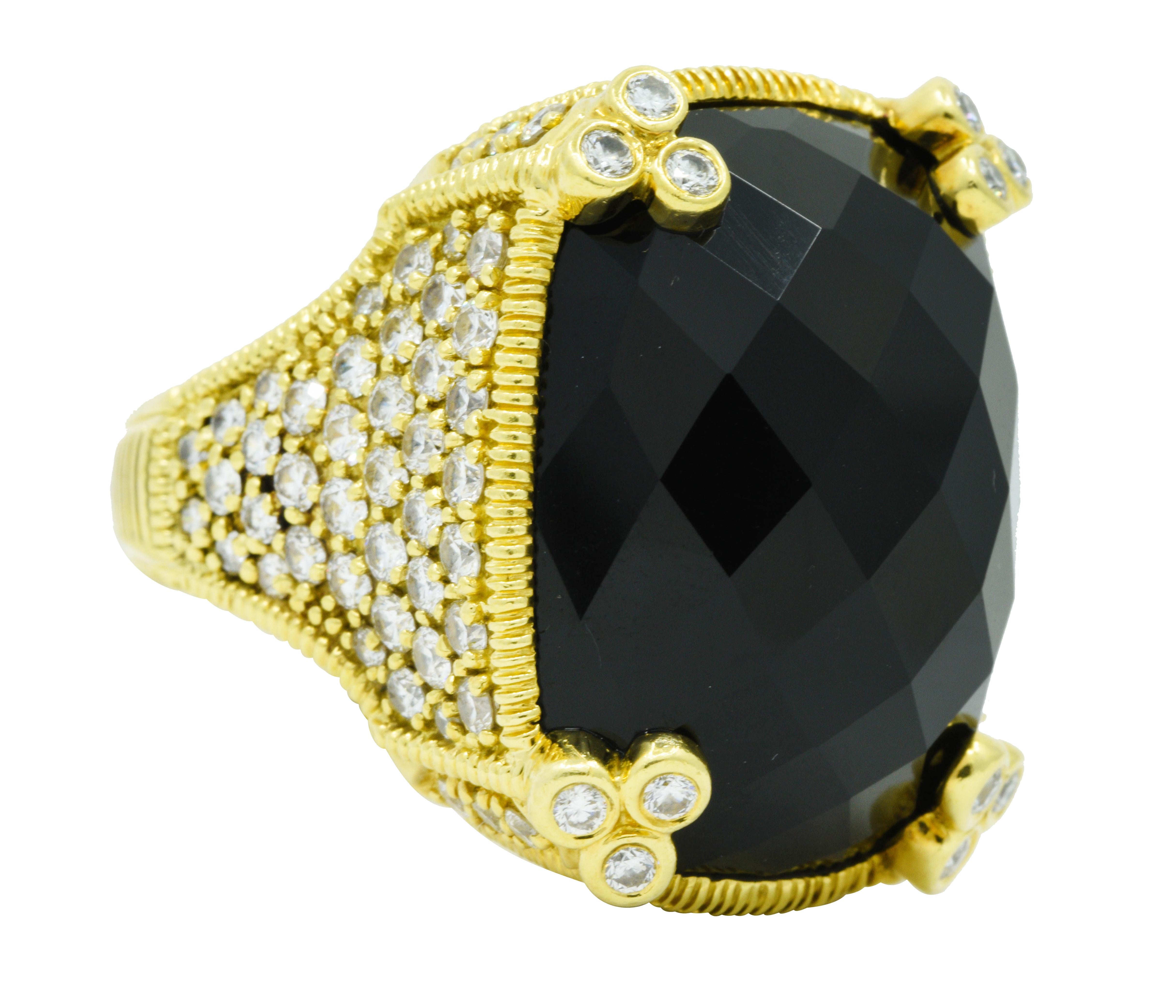 Statement ring centers a cushion checkerboard cut onyx measuring approximately 25.0 x 19.5 mm

Opaque, black, and with an excellent polish - set in place by stylized trefoil prongs

Mounting features ribbed details and is set throughout by round