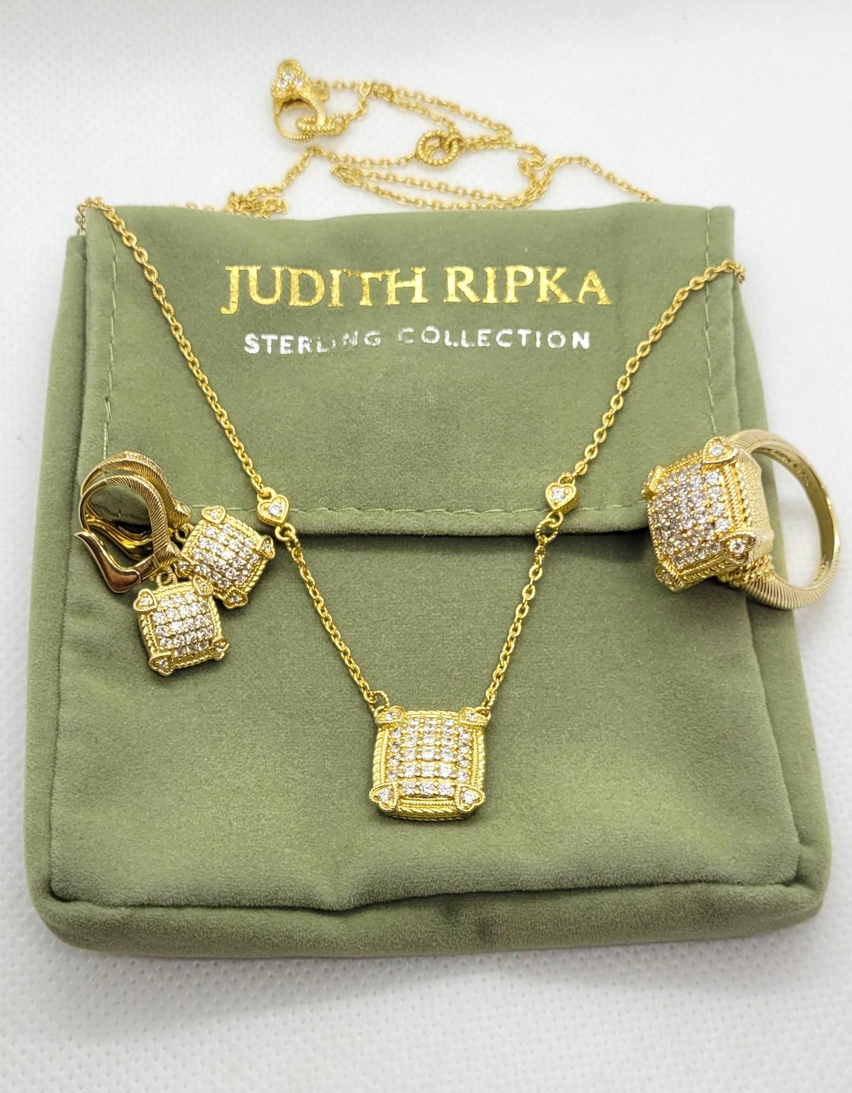 Questo bellissimo set di Judith Ripka comprende una CZ in oro vermeil  collana, orecchini e anello, tutti confezionati in un sacchetto con il marchio. 

La collana misura 19 pollici di lunghezza ed è fissata con una chiusura a moschettone. Ha il